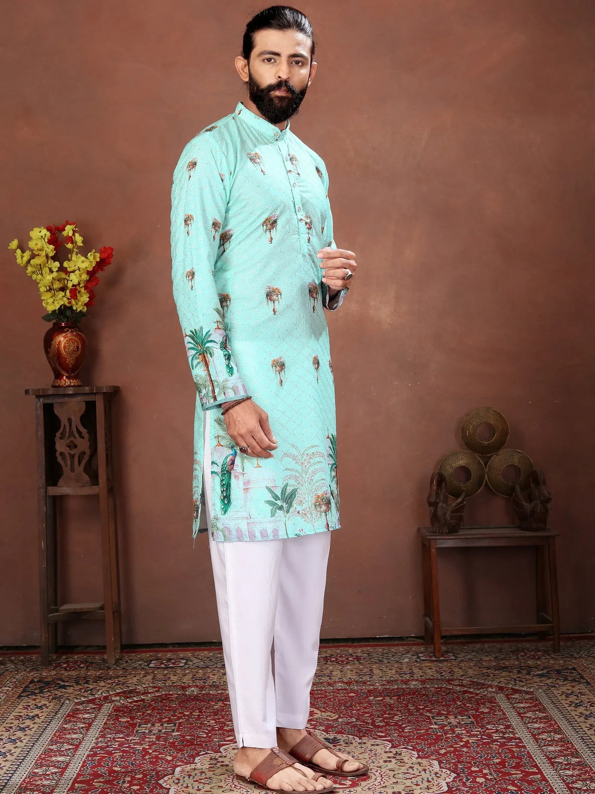 Man in a light blue printed ethnic kurta and white pajama standing in a studio
