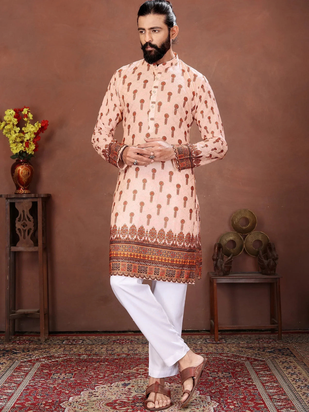 Man wearing a peach printed ethnic kurta with embroidered borders and white pajama pants