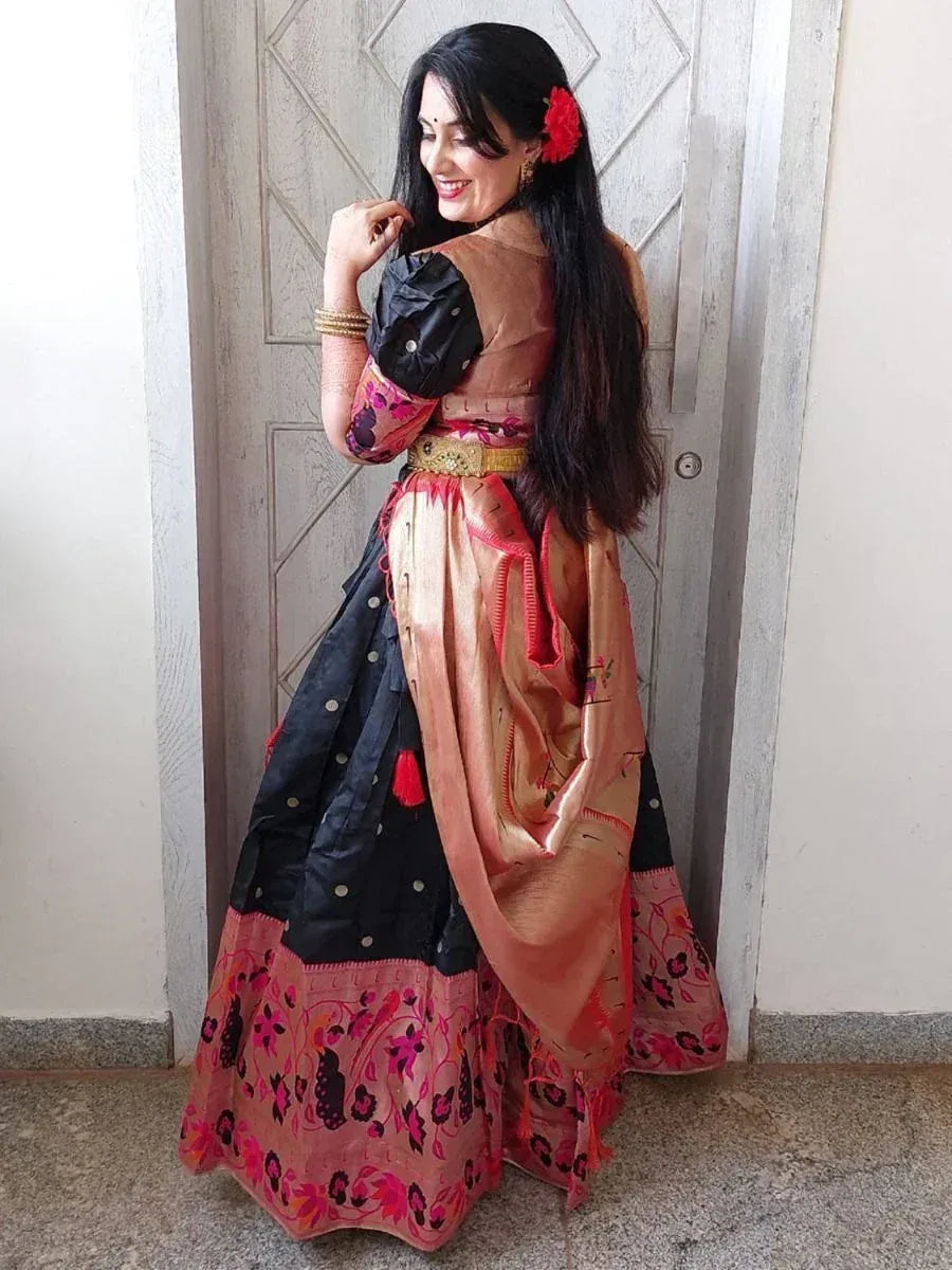 Woman in black and pink floral lehenga choli with gold belt, red flower in hair, ethnic Indian wear