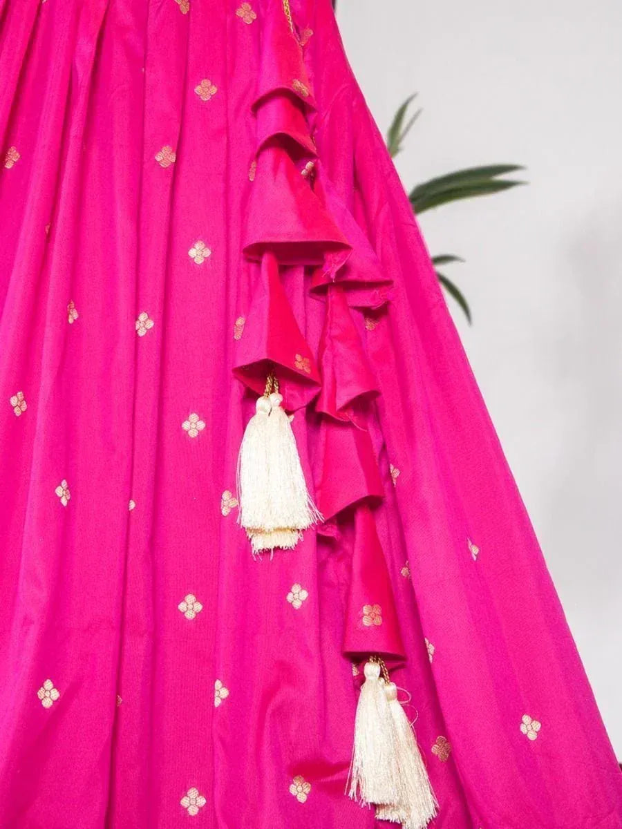 Vibrant pink lehenga with gold floral embroidery and cream tassels, perfect for Indian ethnic wear occasions.