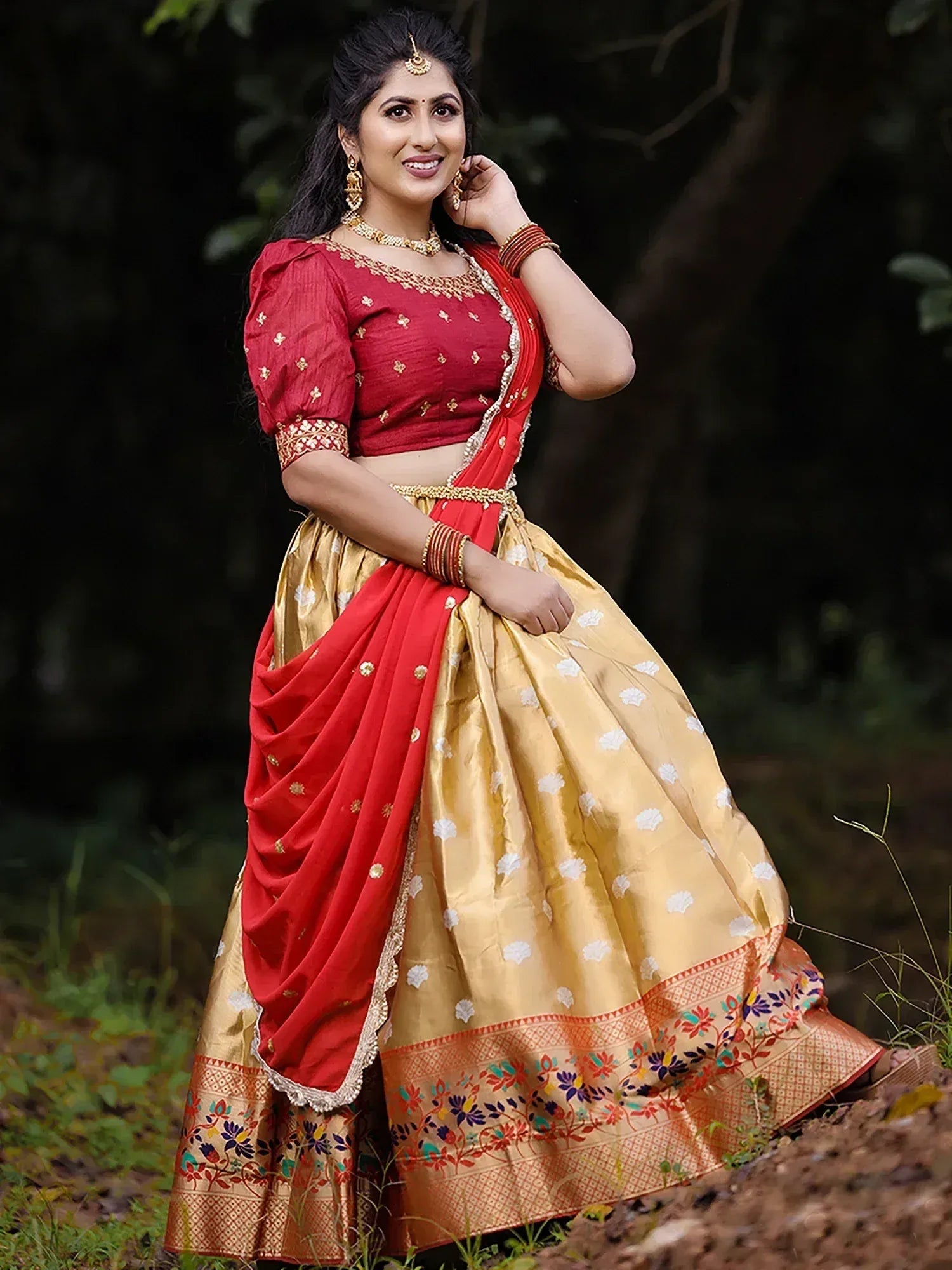 Woman in red and gold designer lehenga choli with floral embroidery, perfect for Indian ethnic occasions