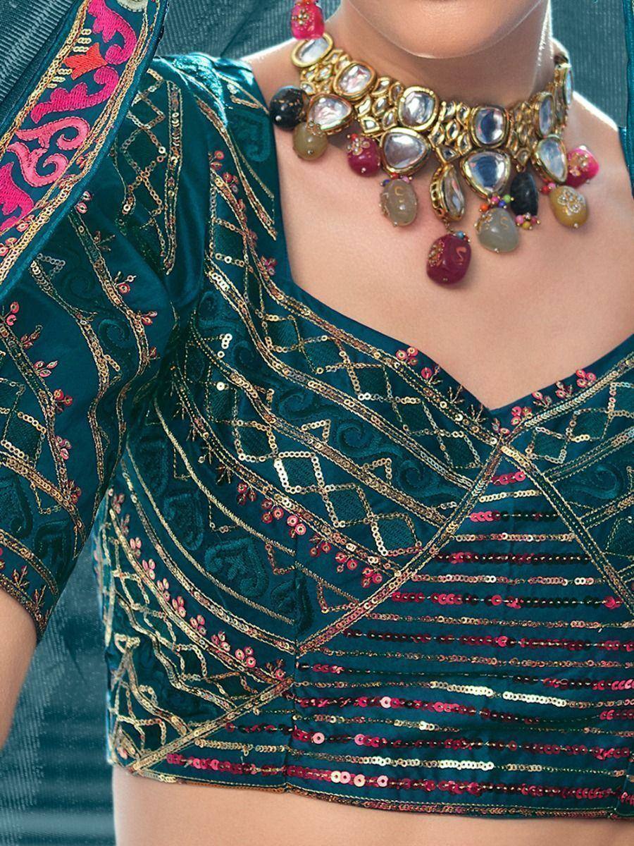 Teal velvet blouse with gold thread and pink sequin embroidery, paired with statement necklace