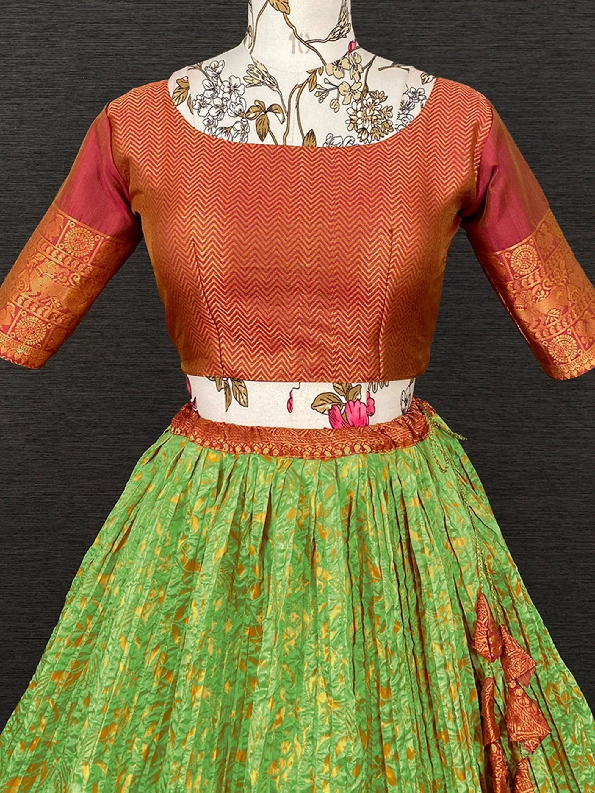 Orange and green ethnic lehenga choli with chevron blouse and floral skirt, perfect for Indian festivals
