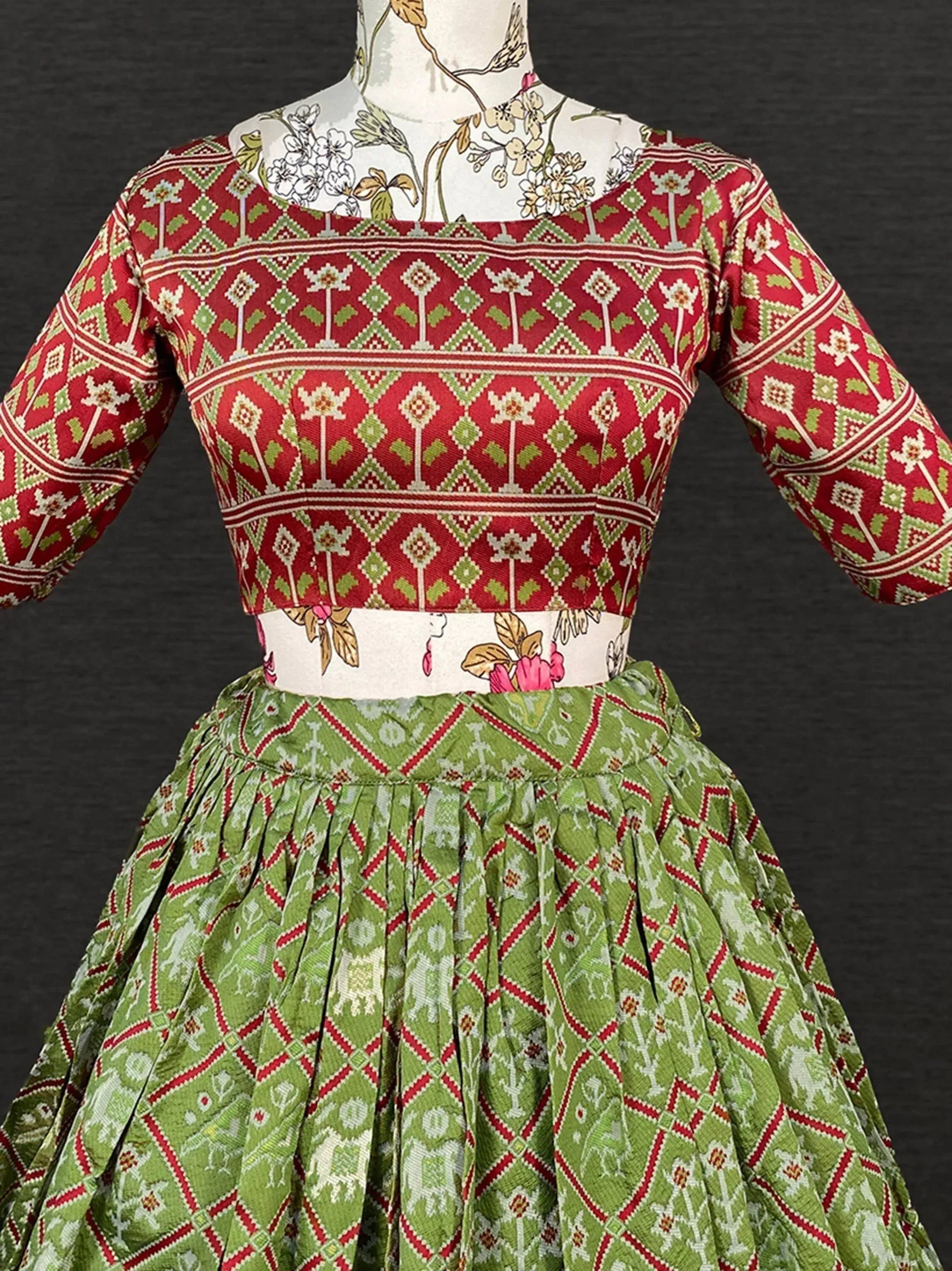 Red and green ethnic lehenga choli with geometric floral print, perfect for Indian festive occasions
