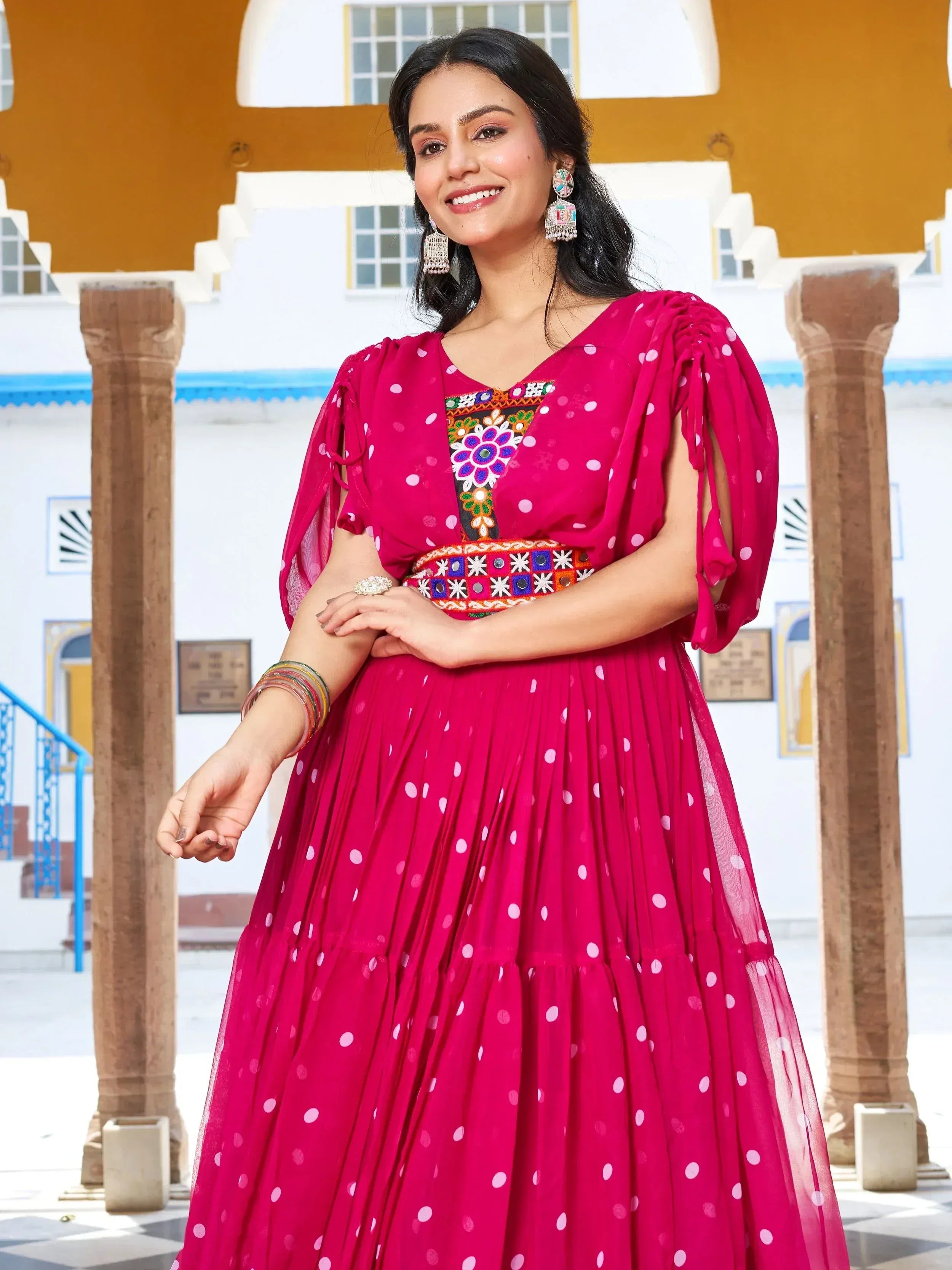 Pink polka dot ethnic gown with embroidered neckline and puff sleeves, perfect for Indian festive occasions.