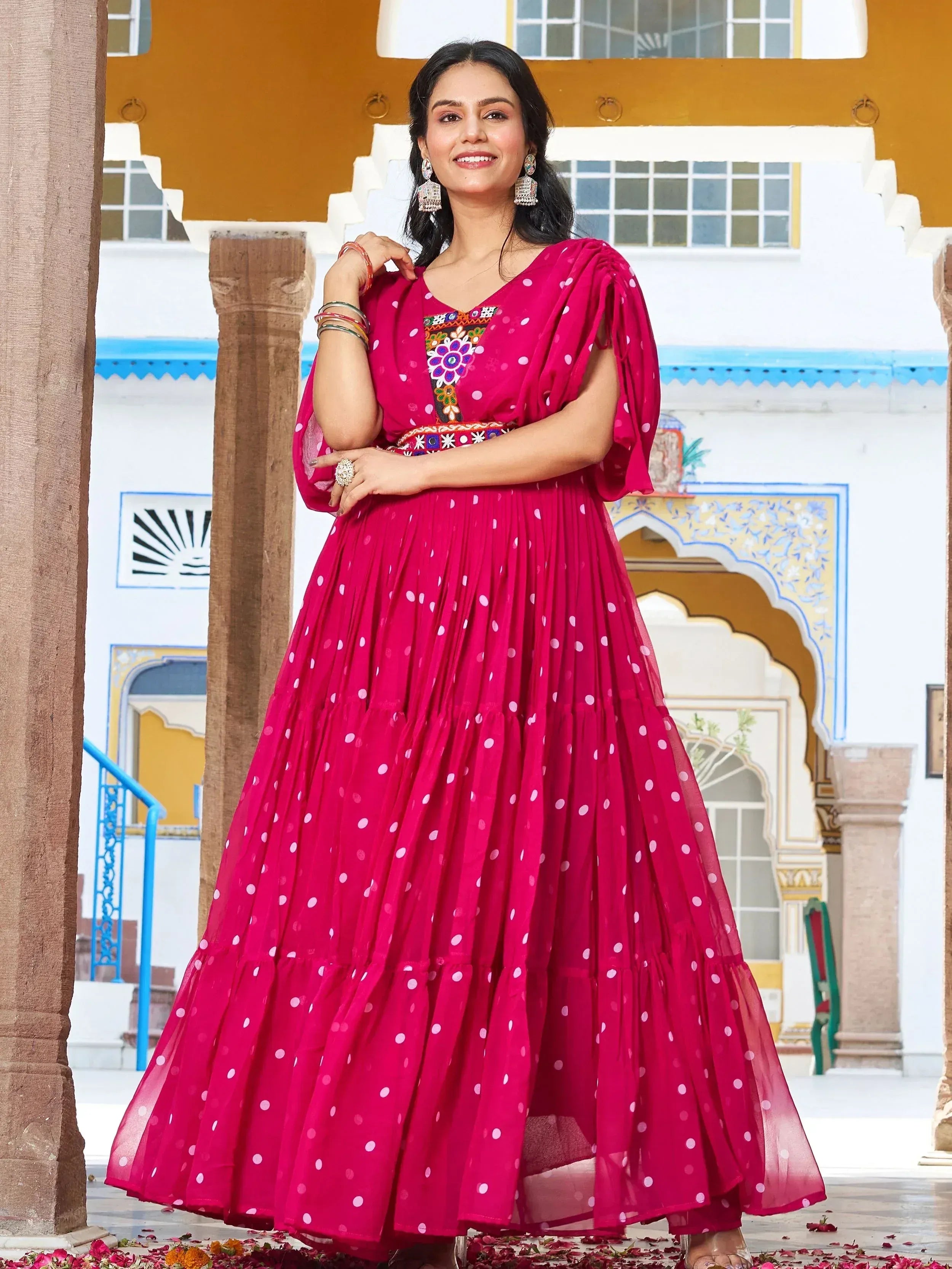 Woman in vibrant pink polka dot ethnic gown with embroidery, perfect for Indian celebrations
