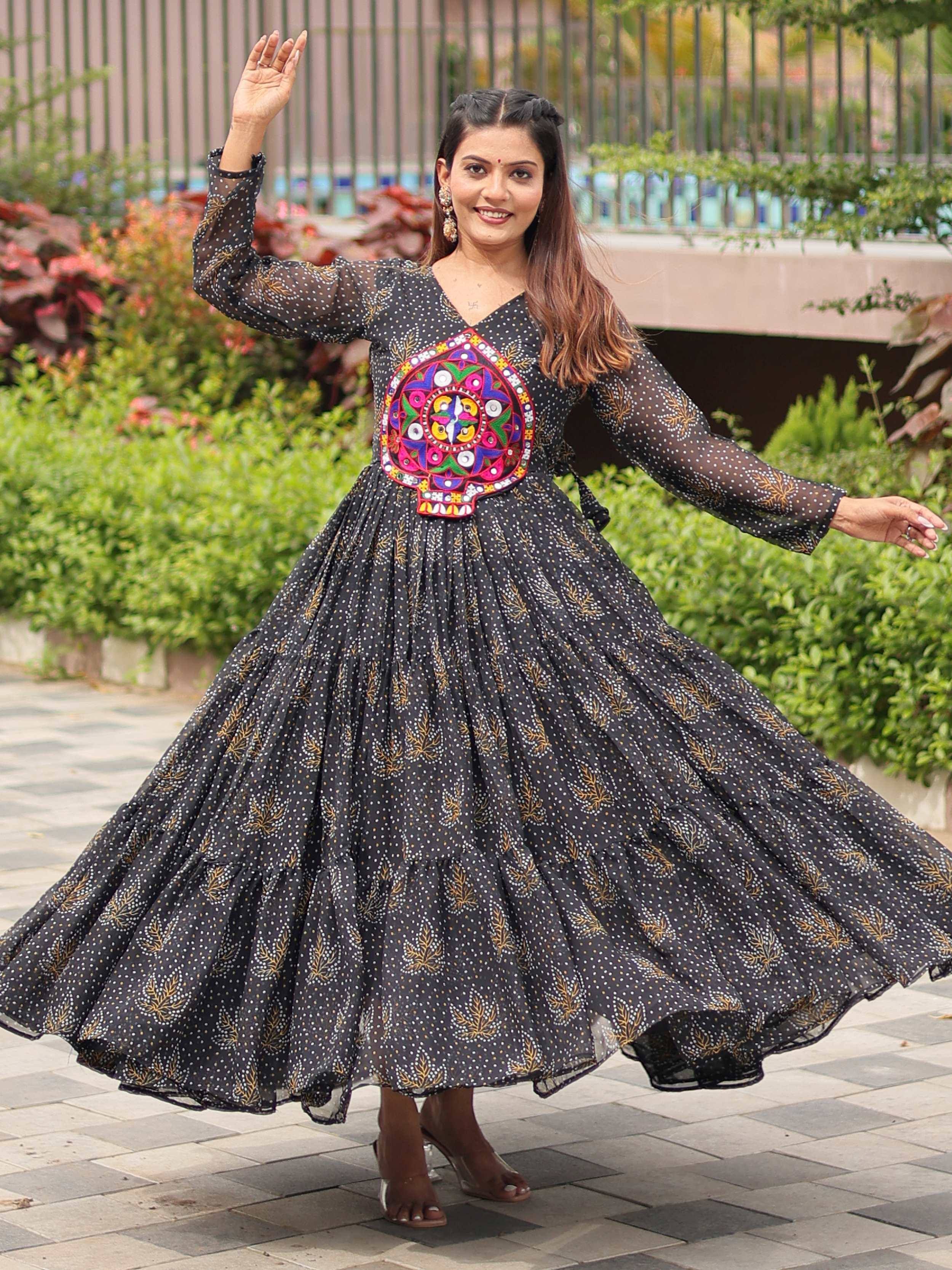 Woman twirling in black ethnic gown with colorful mirror work, perfect for Indian occasions