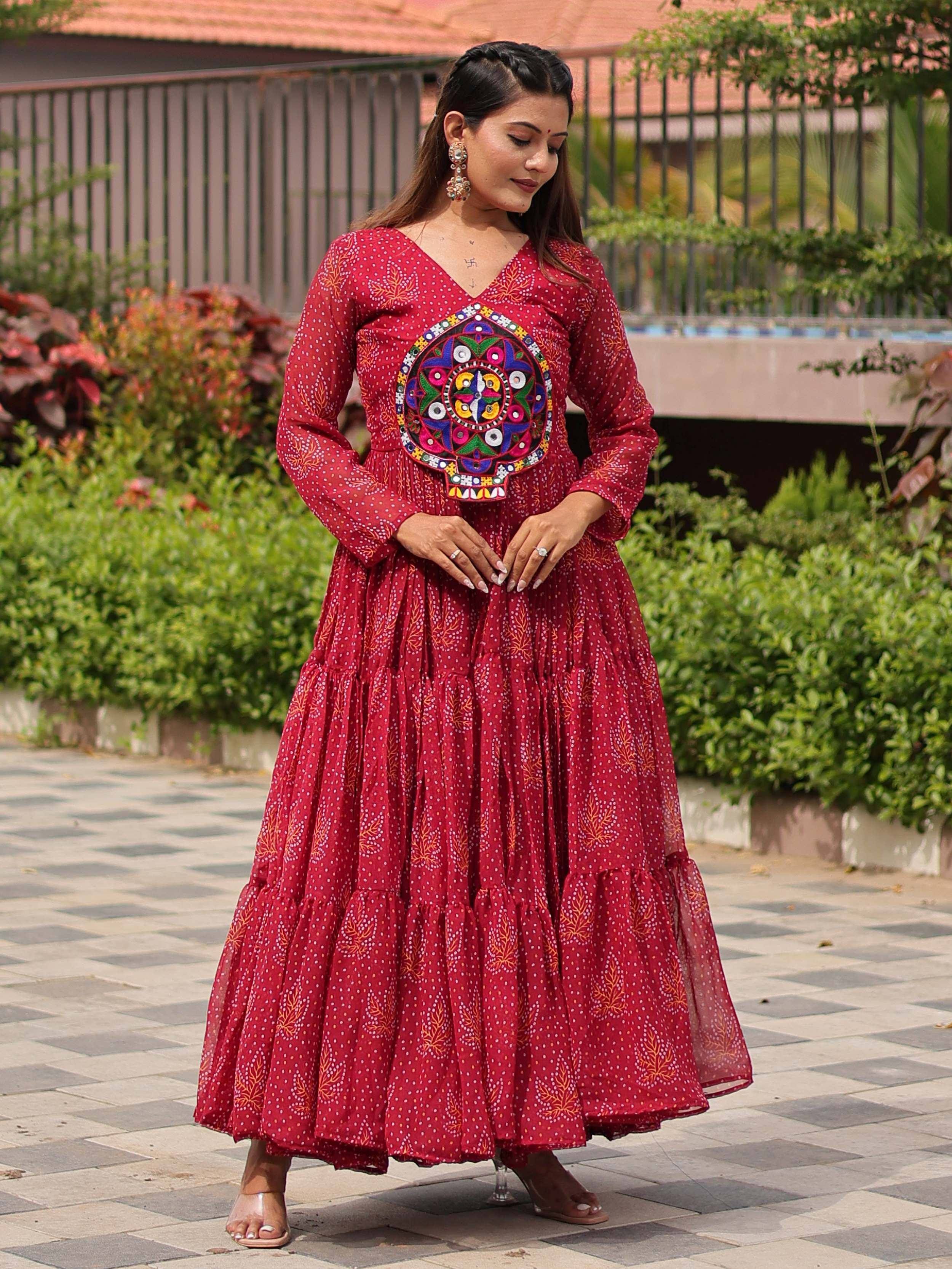 Red ethnic gown with mirror work and printed motifs, perfect for Indian festive occasions