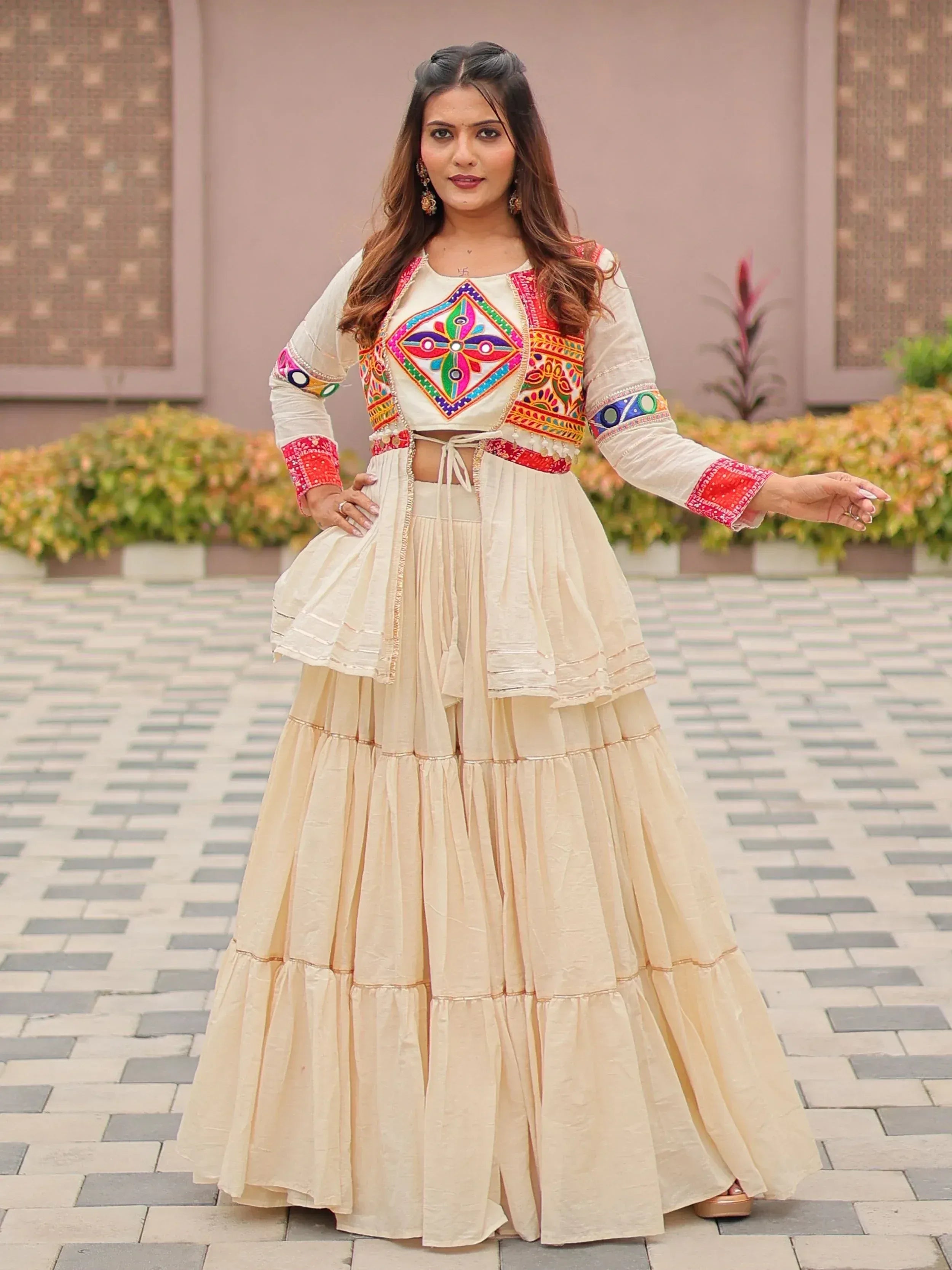 Woman in cream embroidered lehenga choli with colorful mirror work, perfect for Indian ethnic occasions