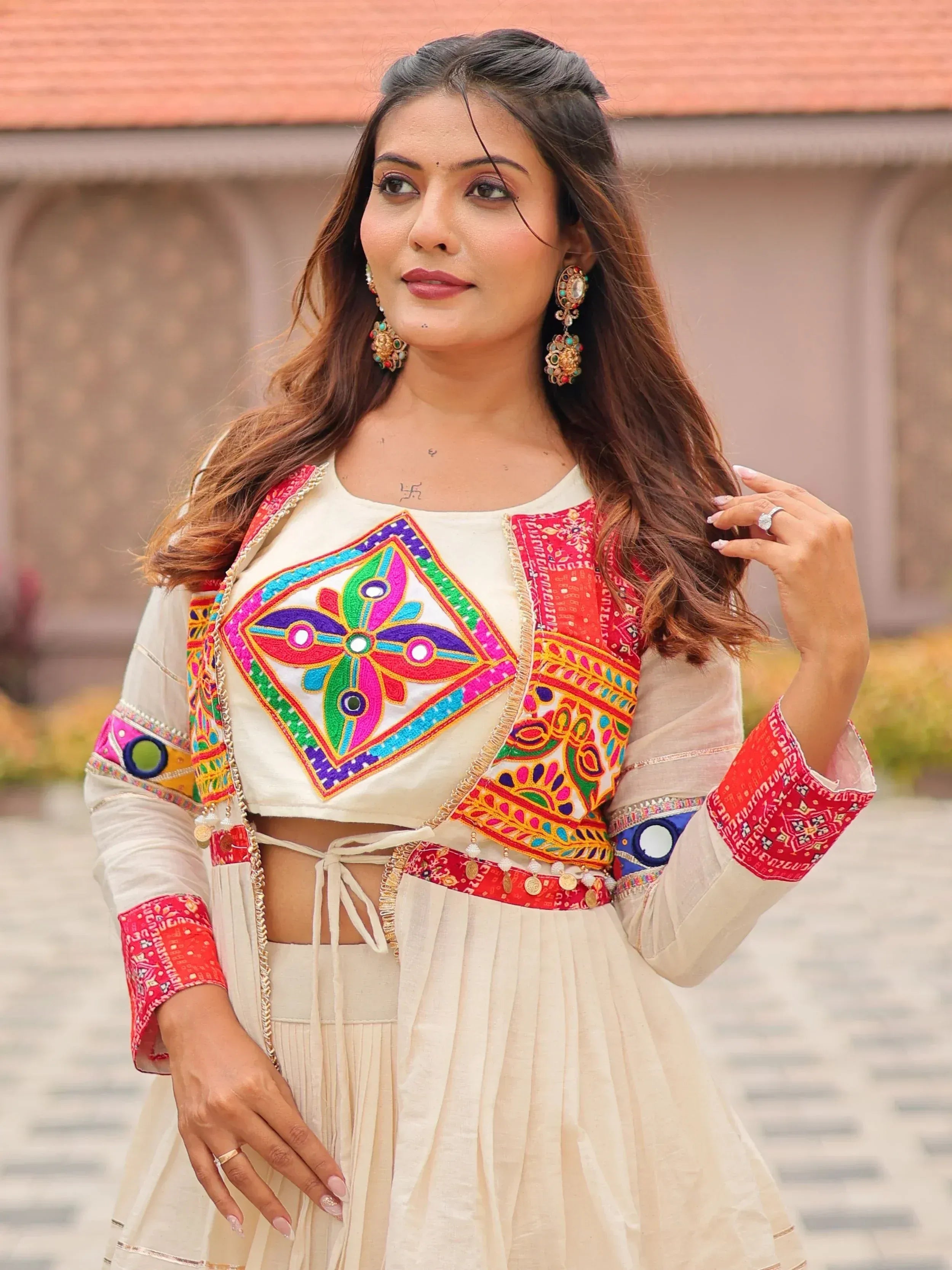 Woman in vibrant embroidered Indian ethnic wear with mirror work and colorful patterns