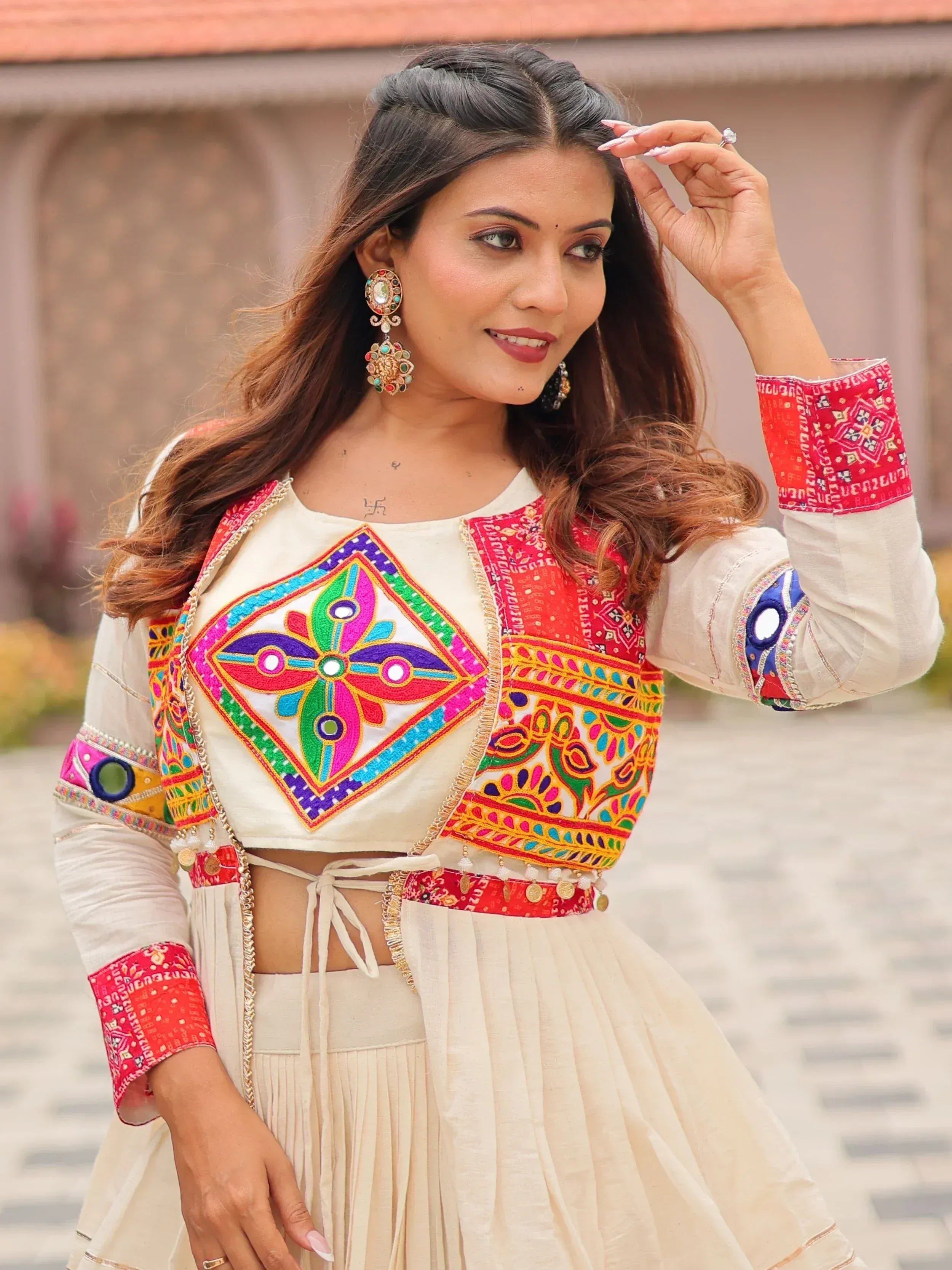 Colorful embroidered Indian ethnic top with mirror work, paired with pleated skirt, perfect for festive occasions.