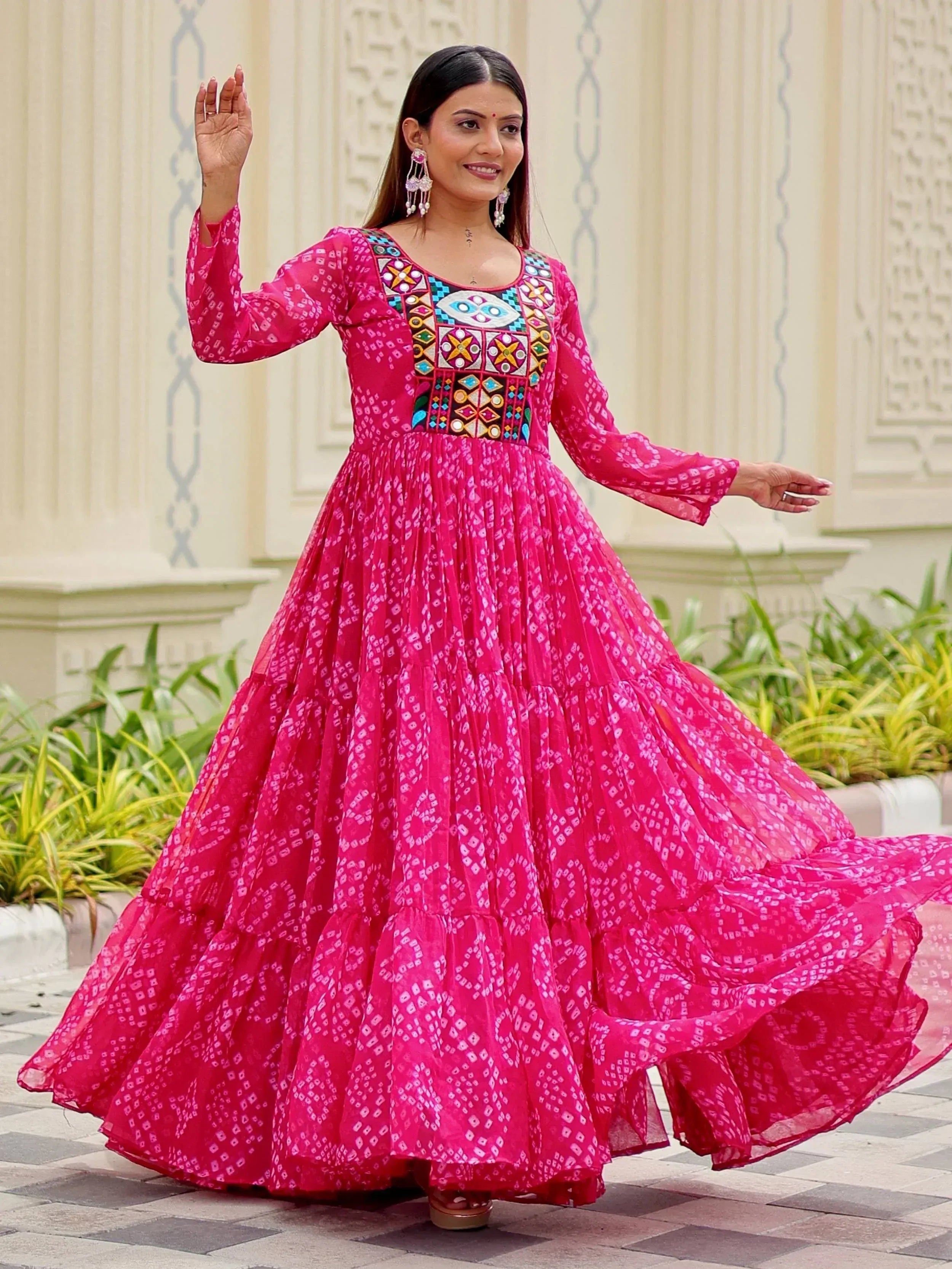 Pink ethnic gown with mirror work and tiered skirt, perfect for Indian festive occasions
