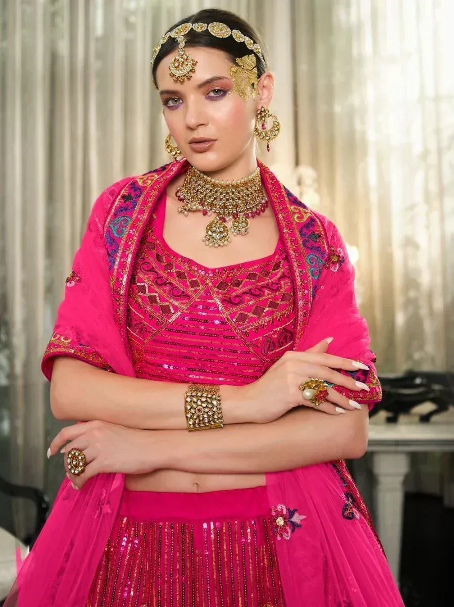 Pink embroidered lehenga choli with gold jewelry, perfect for Indian weddings and festive occasions