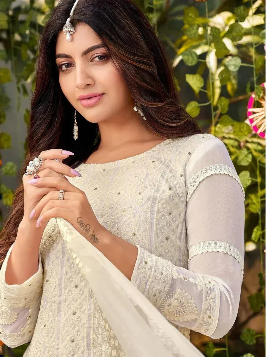 Elegant white embroidered ethnic gown with lace sleeves and traditional jewelry