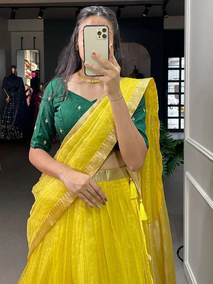 Yellow saree with green blouse, gold border, and tassels, styled for ethnic wear