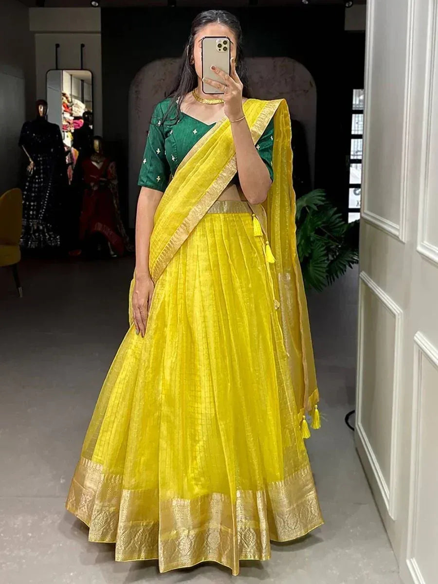 Yellow lehenga choli with green blouse, gold border, and tassels, perfect for Indian ethnic occasions.