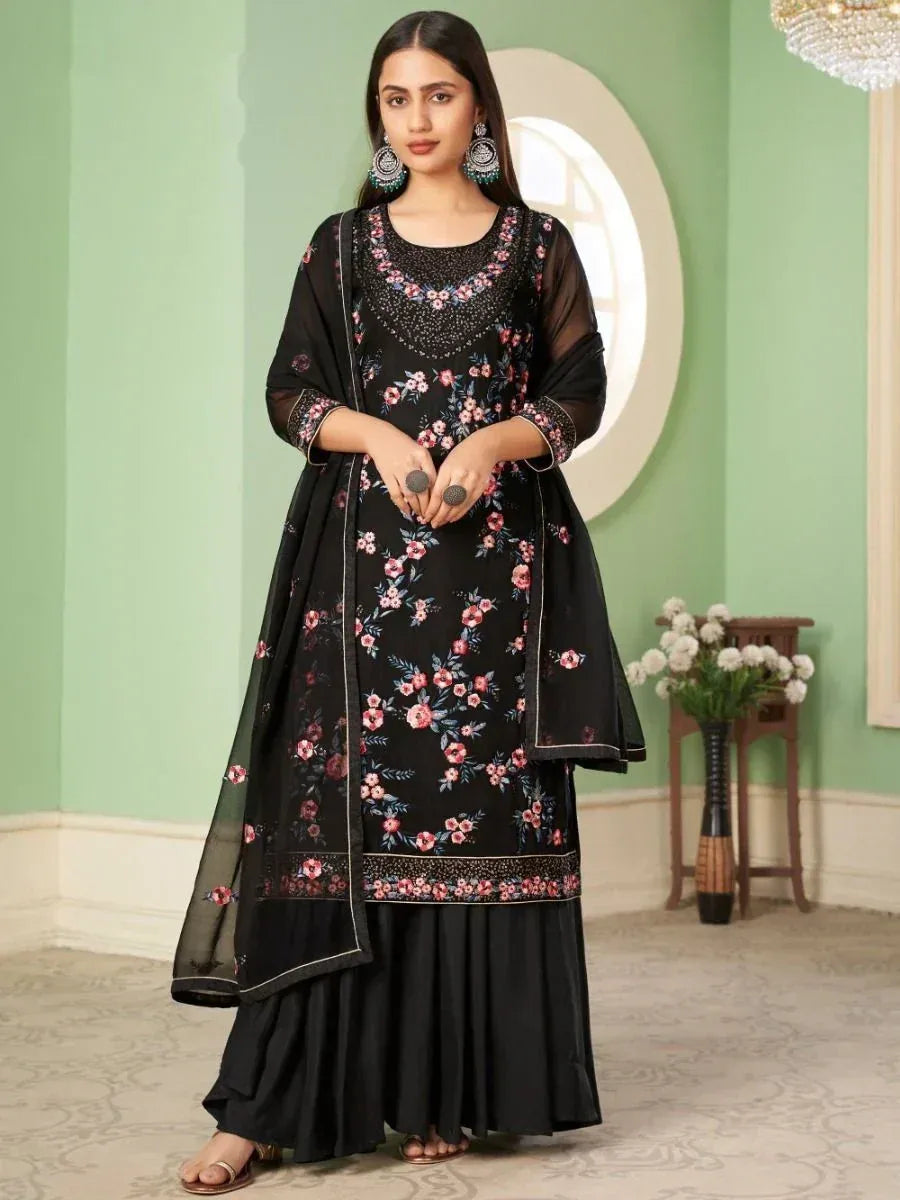 Woman wearing black floral embroidered salwar kameez with matching dupatta indoors