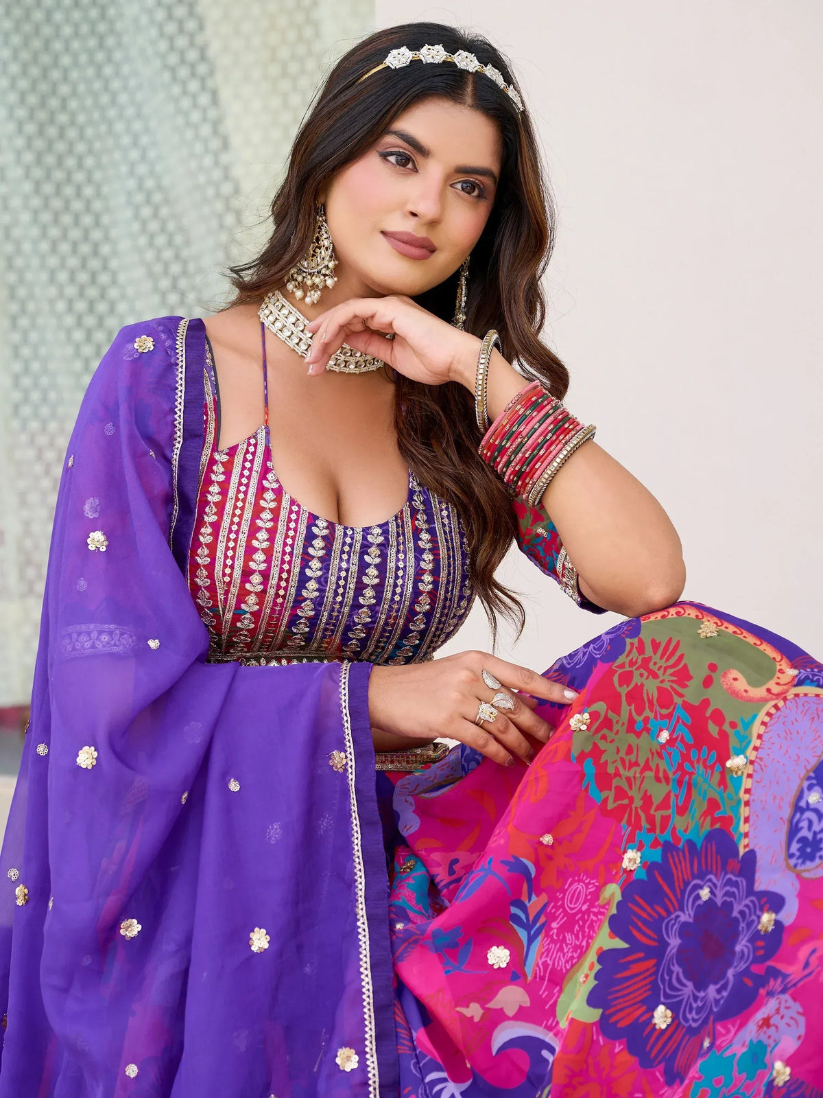 Woman in vibrant purple and pink embroidered lehenga choli with floral dupatta, traditional Indian ethnic wear