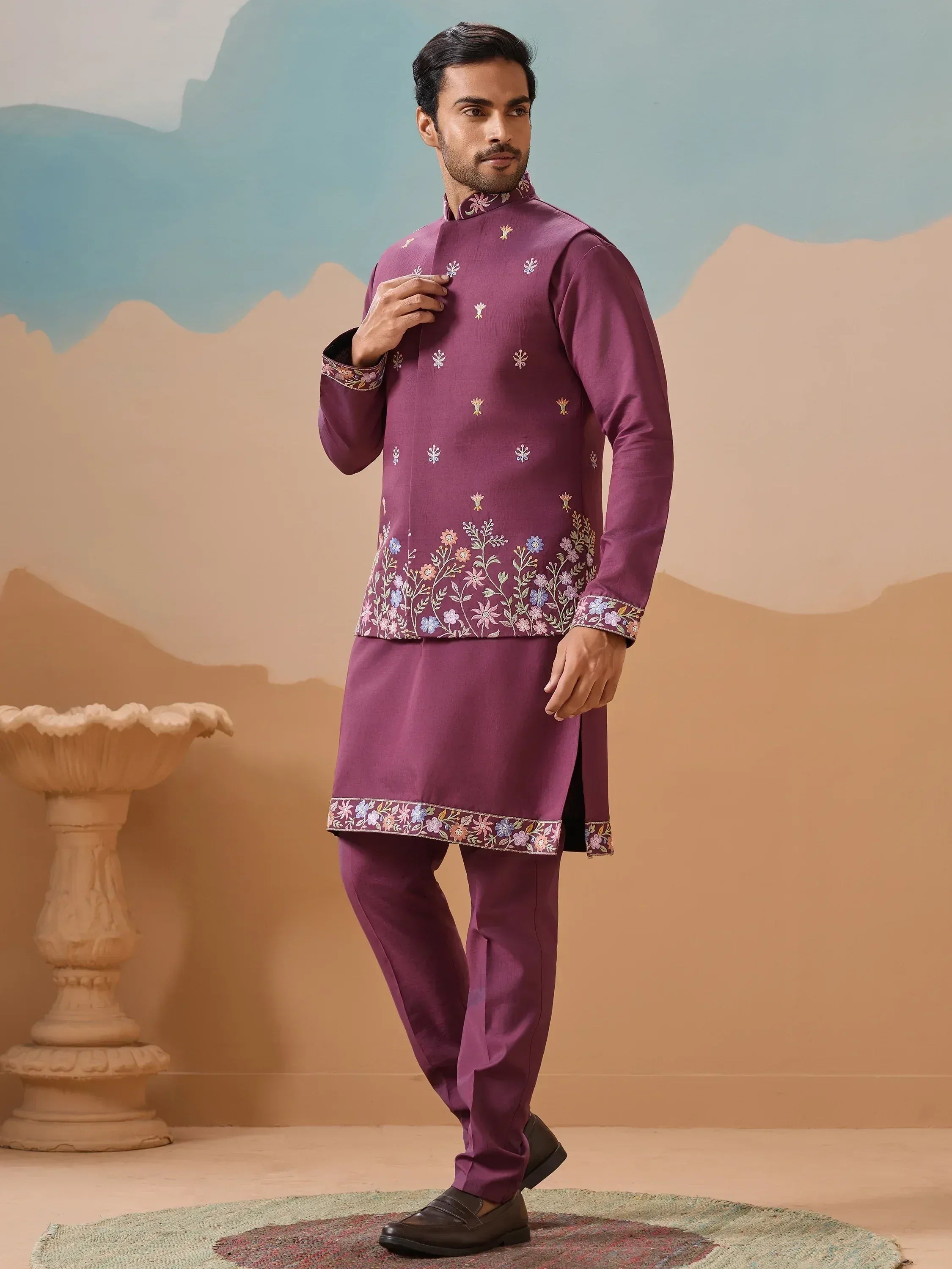 Man in purple embroidered kurta pajama set with floral detailing, ideal for Indian ethnic occasions