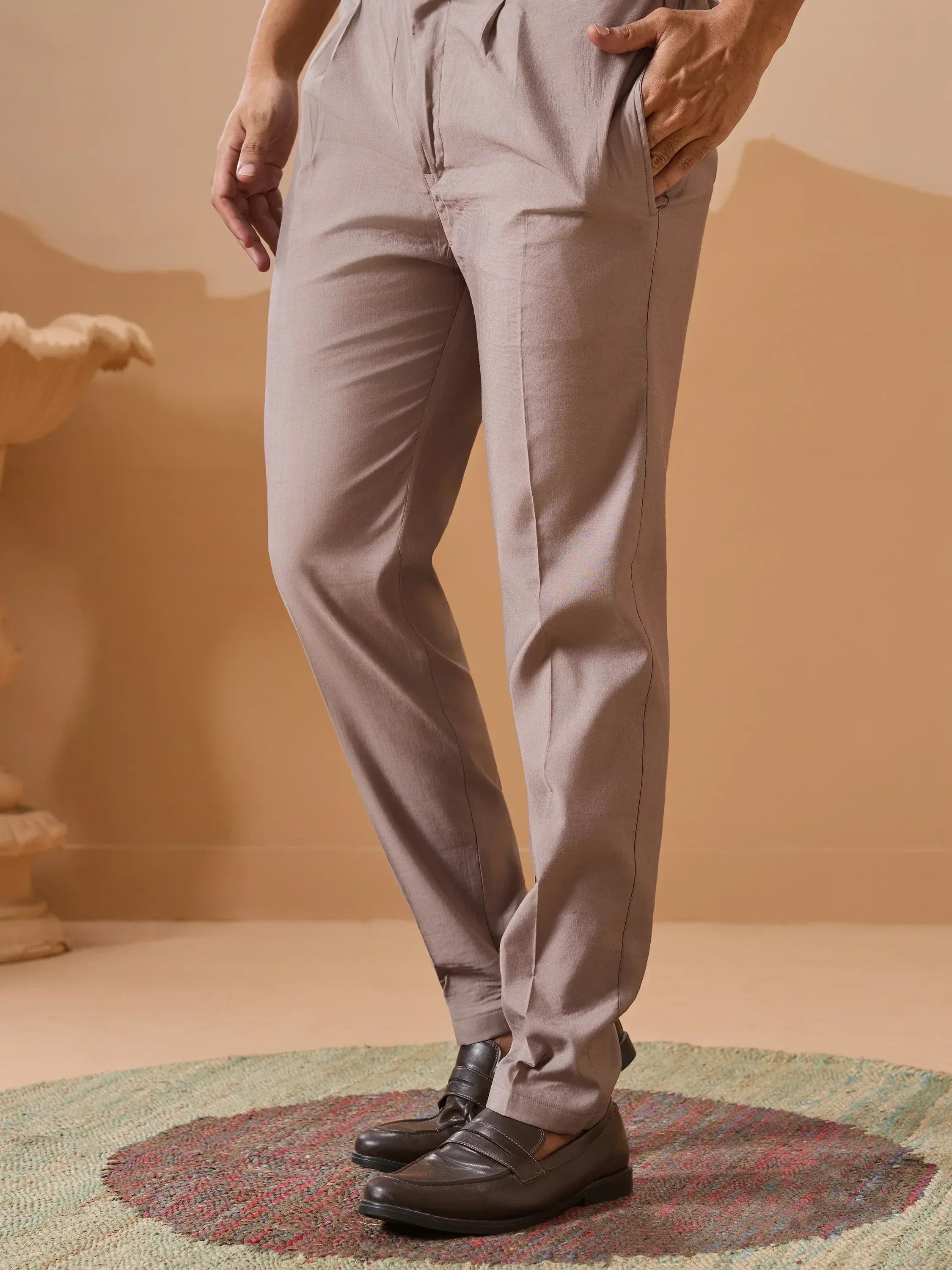Beige pleated trousers with black loafers, styled for ethnic wear
