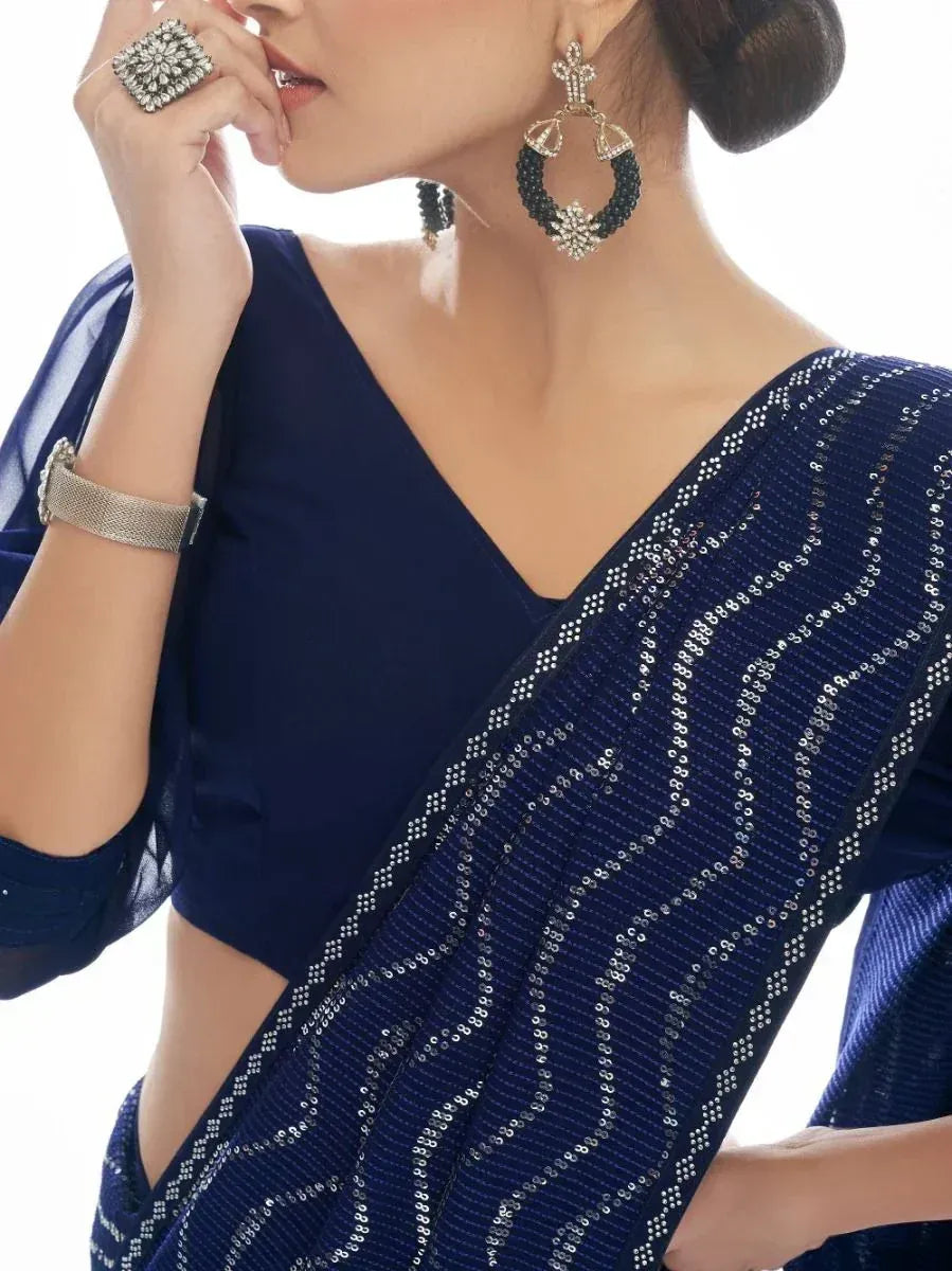 Navy blue sequin saree with designer blouse, statement earrings, and ring for ethnic wear