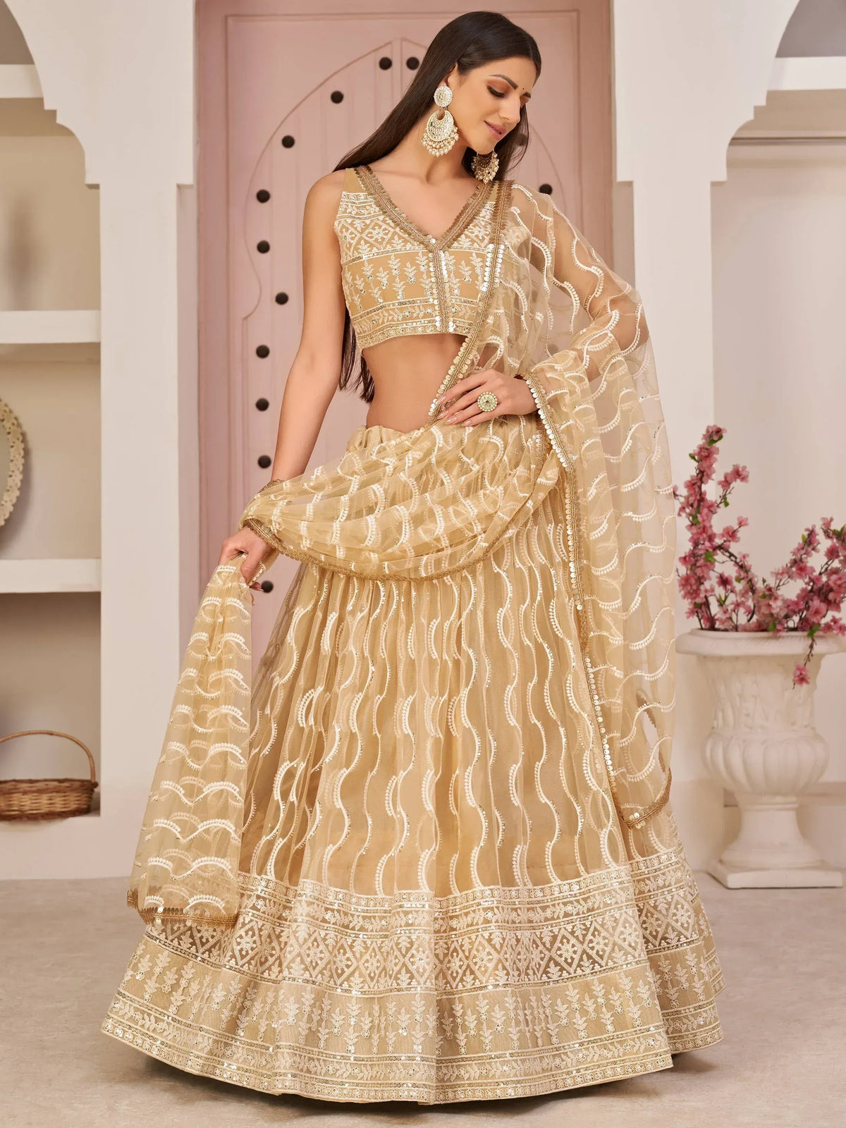 Beige designer lehenga choli with intricate embroidery and sequin work, perfect for weddings and festive occasions.