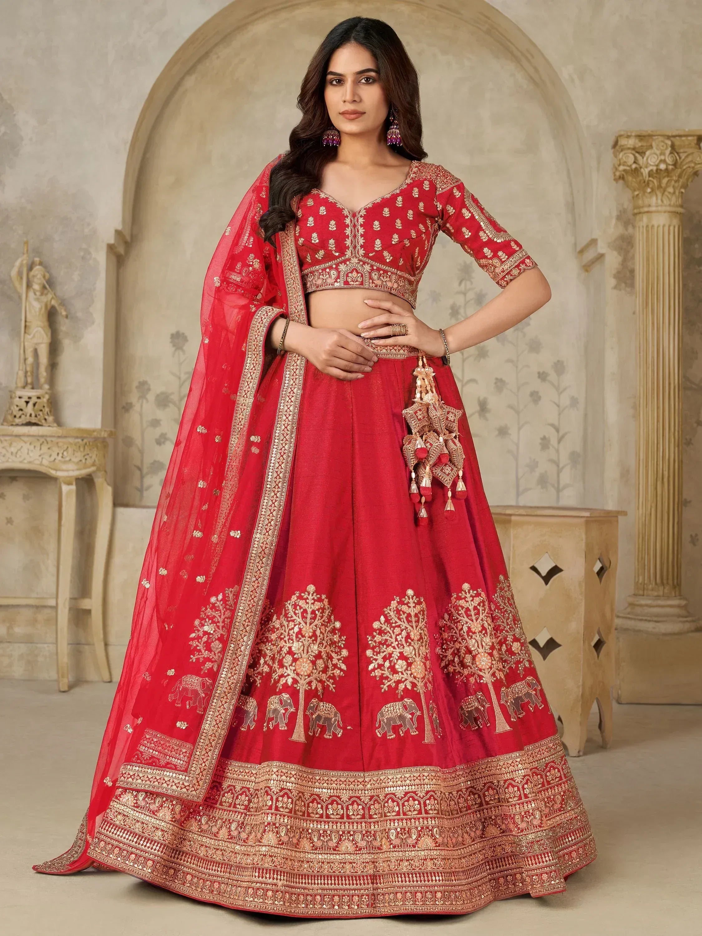 Red embroidered lehenga choli with gold tree and elephant motifs, perfect for Indian weddings and festivals