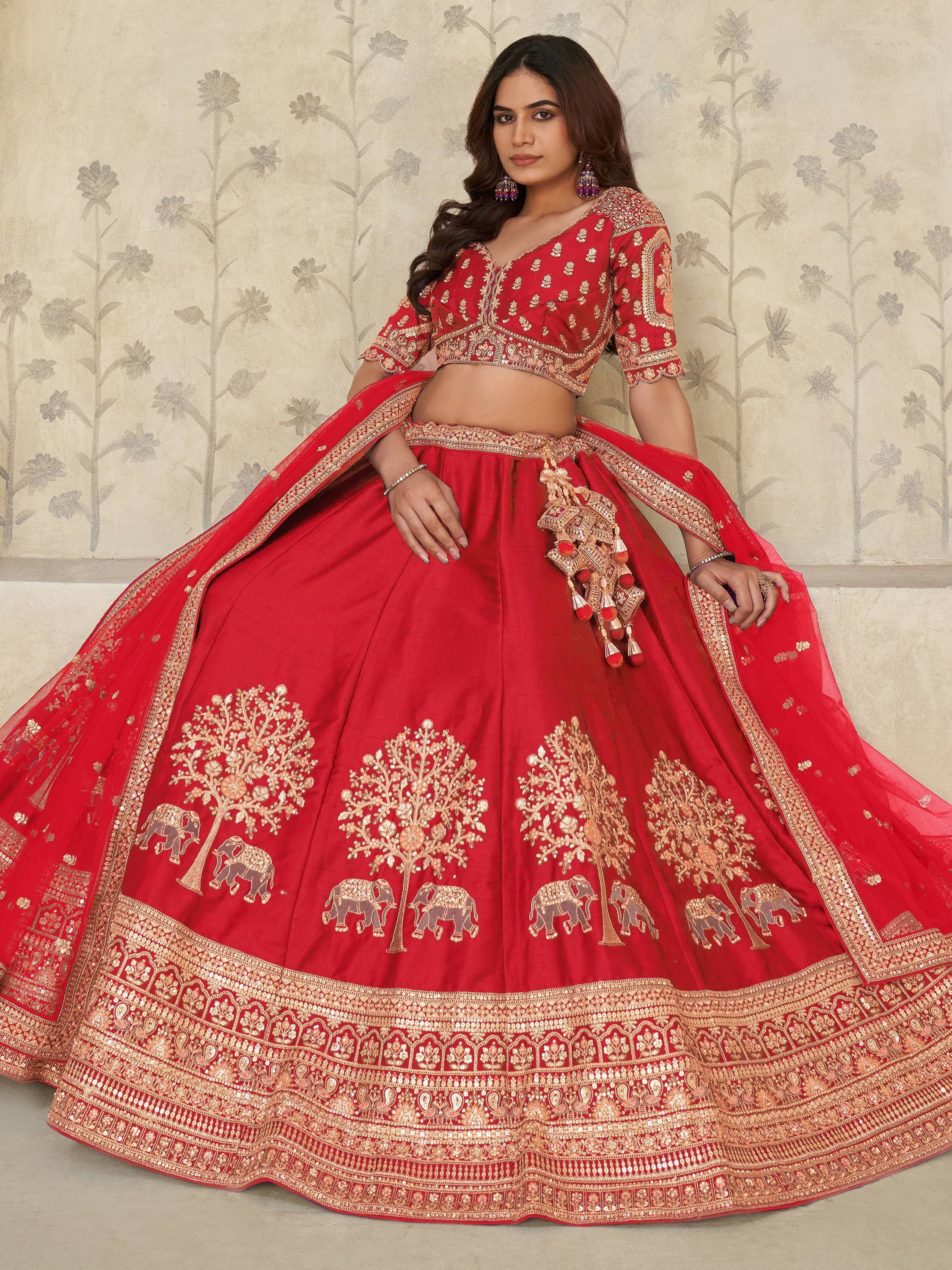 Red designer lehenga choli with gold embroidery, elephant and tree motifs, perfect for Indian weddings and festivals