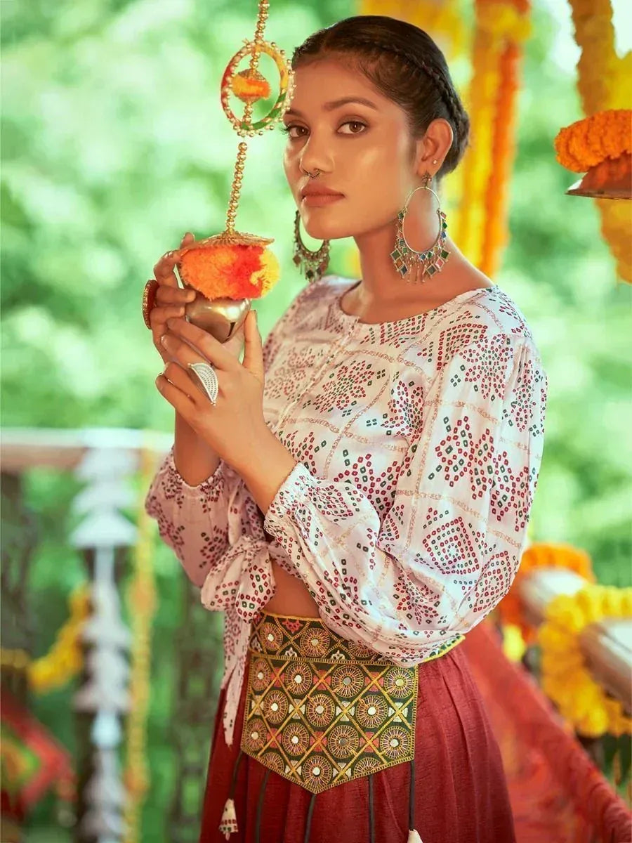 Woman in embroidered ethnic blouse and maroon skirt holding ceremonial kalash, festive Indian attire