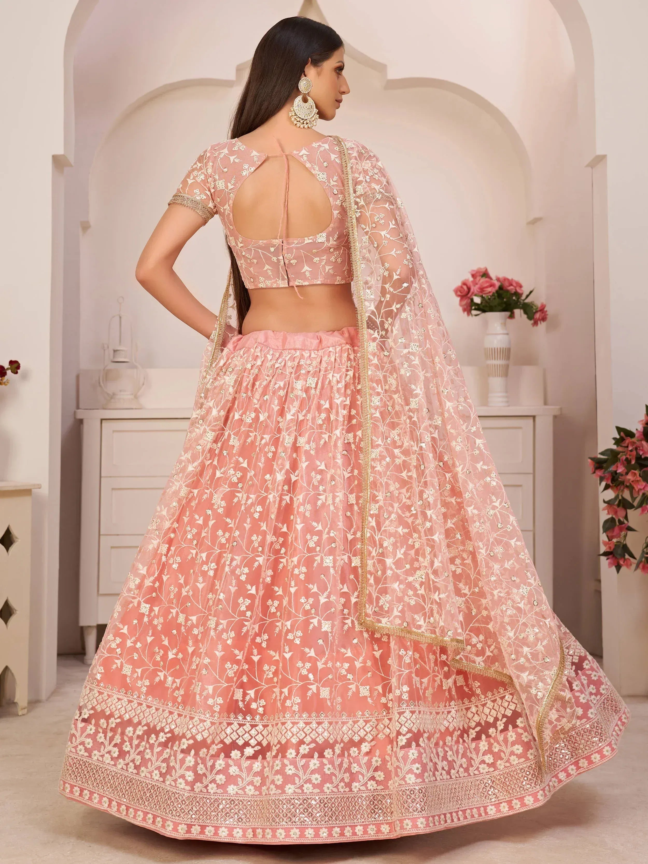 Pink embroidered lehenga choli with floral design and gold trim, perfect for Indian ethnic wear occasions