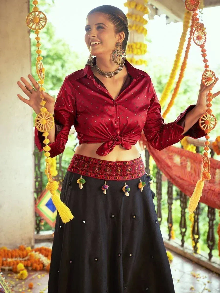 Woman in red satin crop top and black embroidered skirt, festive Indian ethnic wear with floral decor
