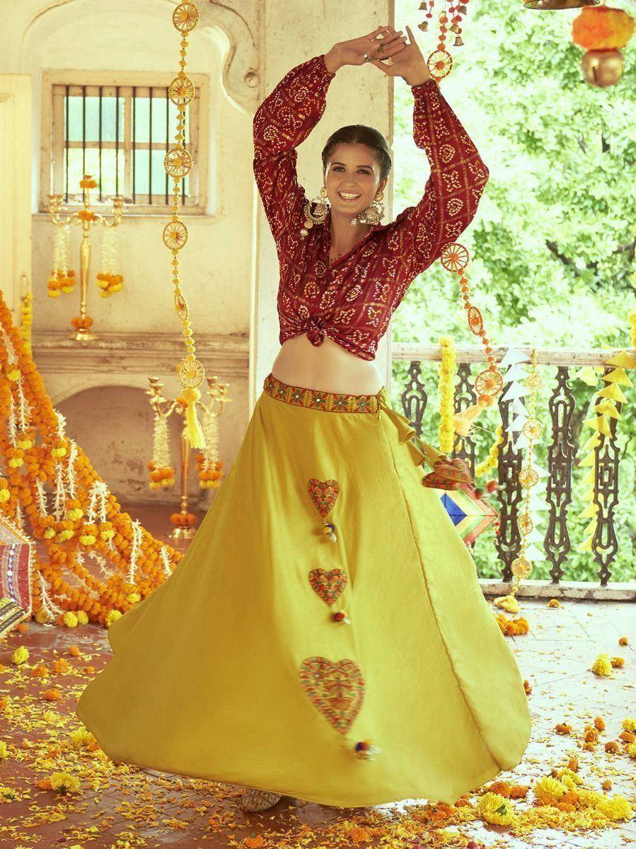 Woman in red printed crop top and yellow lehenga with heart embroidery, festive Indian ethnic wear
