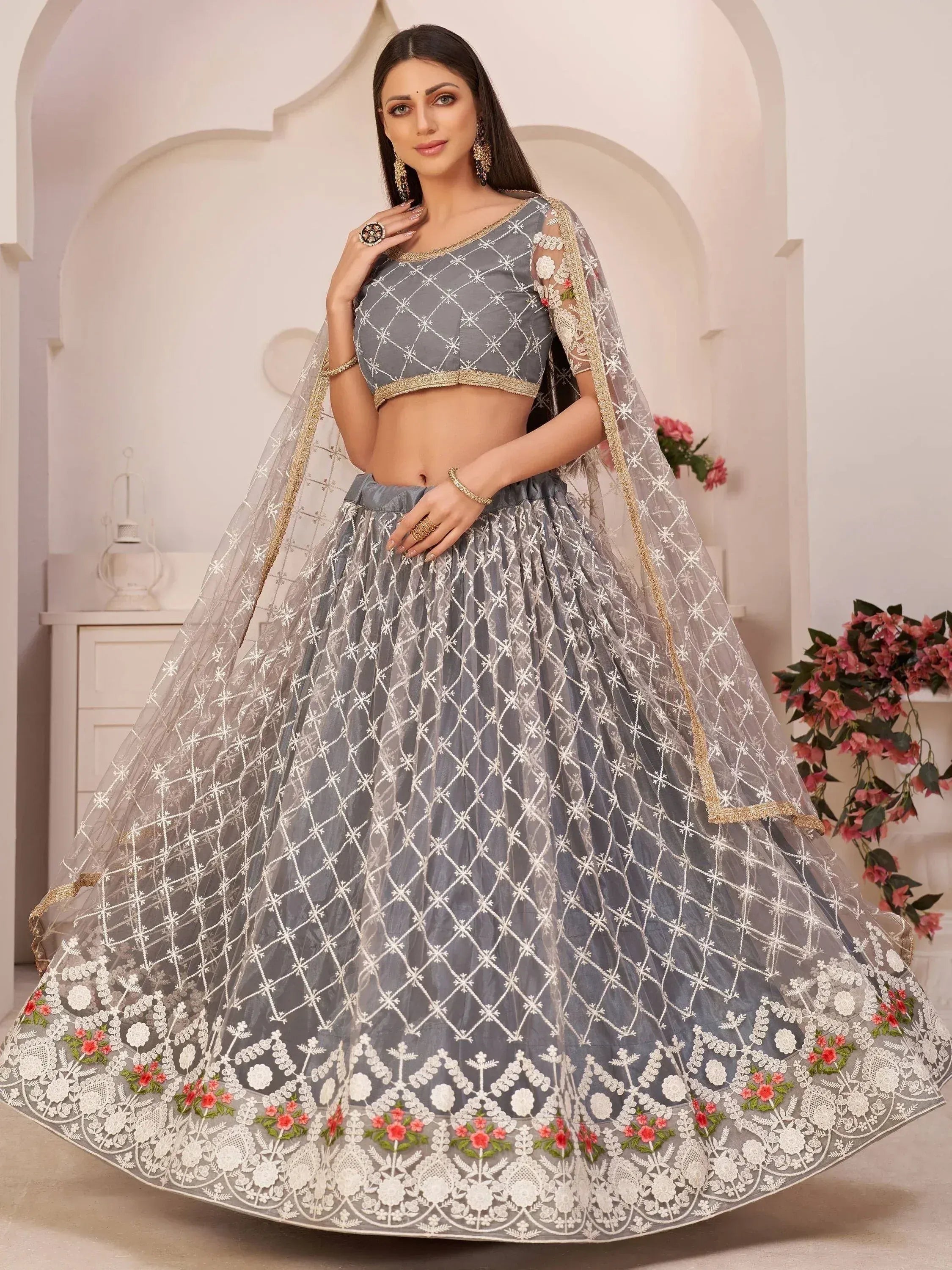 Grey designer lehenga choli with white floral embroidery and gold trim, perfect for Indian weddings or festive occasions.