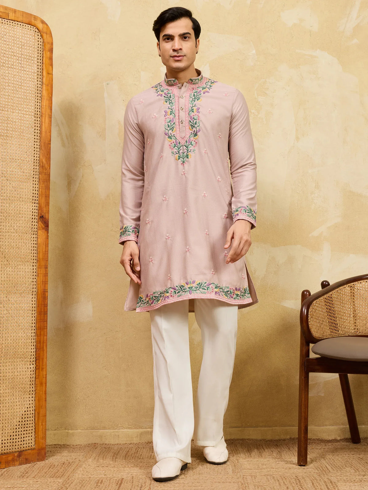 Man wearing a dusty pink embroidered kurta with white trousers