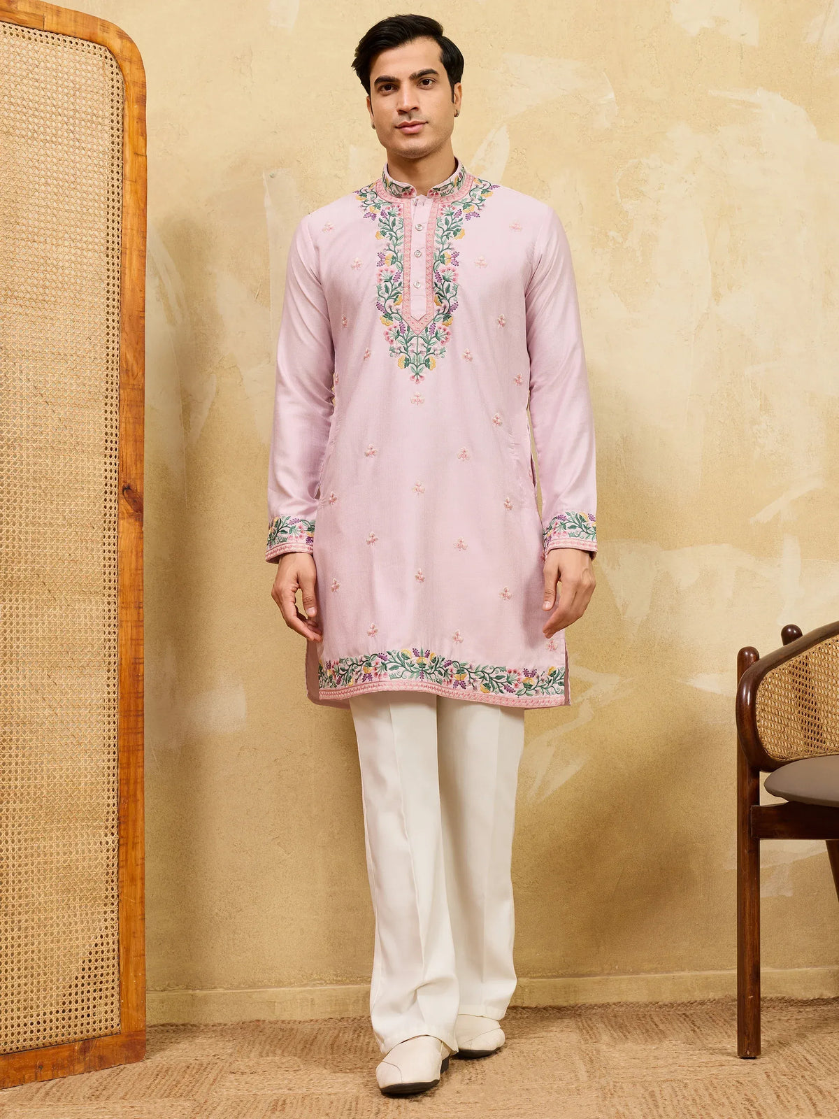 Man wearing a light pink embroidered ethnic kurta with white trousers