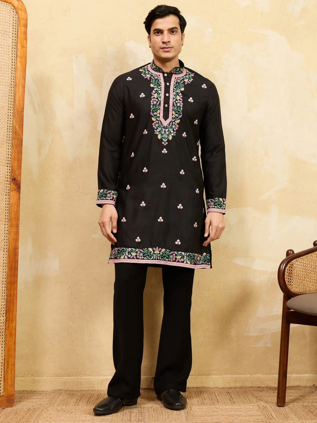 Man wearing a black embroidered kurta pajama set with floral detailing
