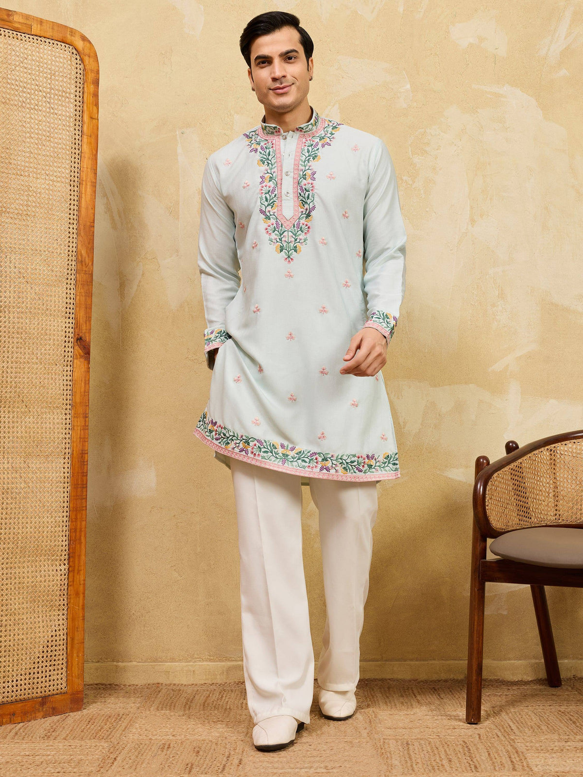 Man wearing a light blue embroidered ethnic kurta with white trousers