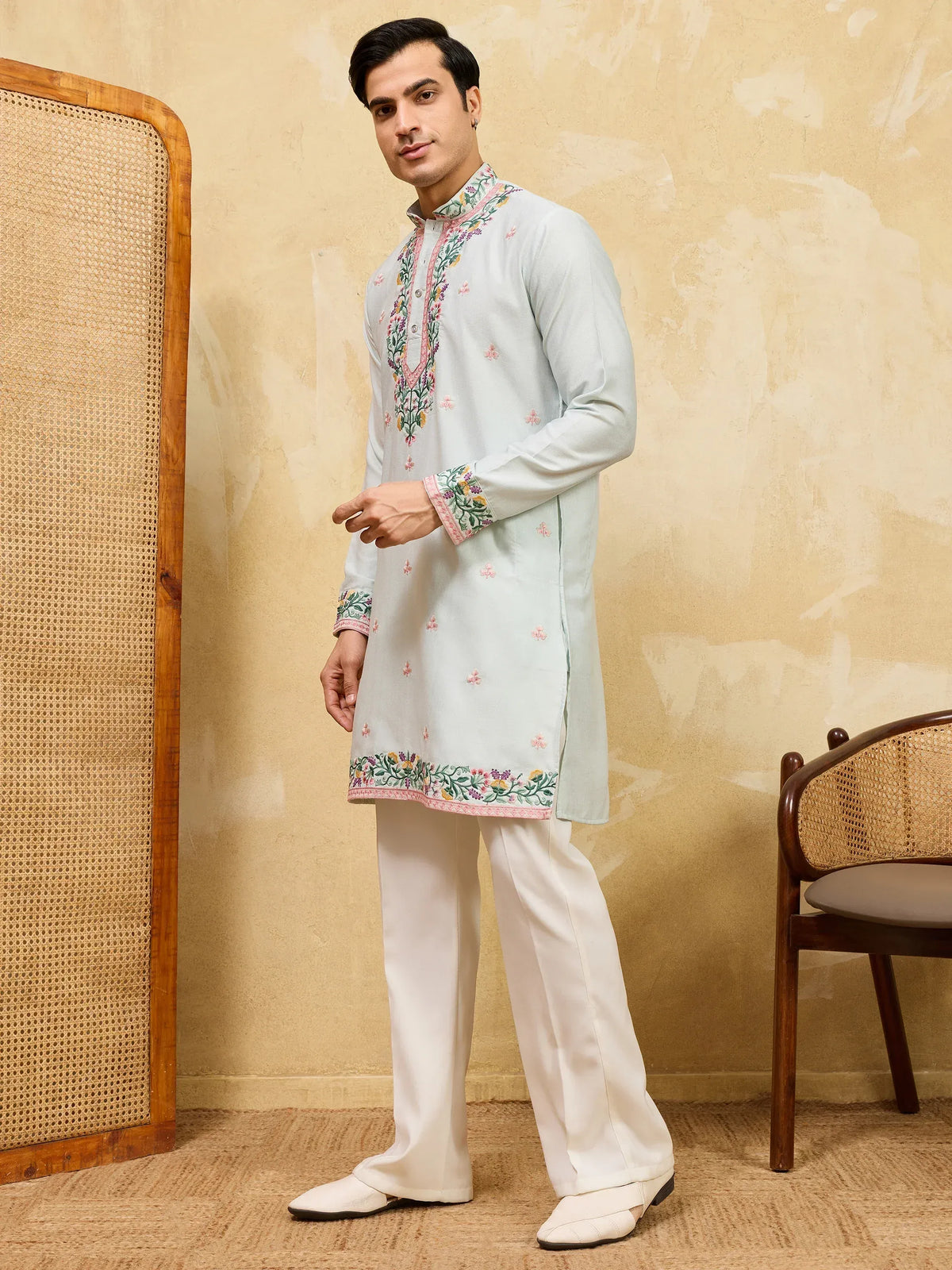 Man wearing a light blue embroidered kurta with white trousers