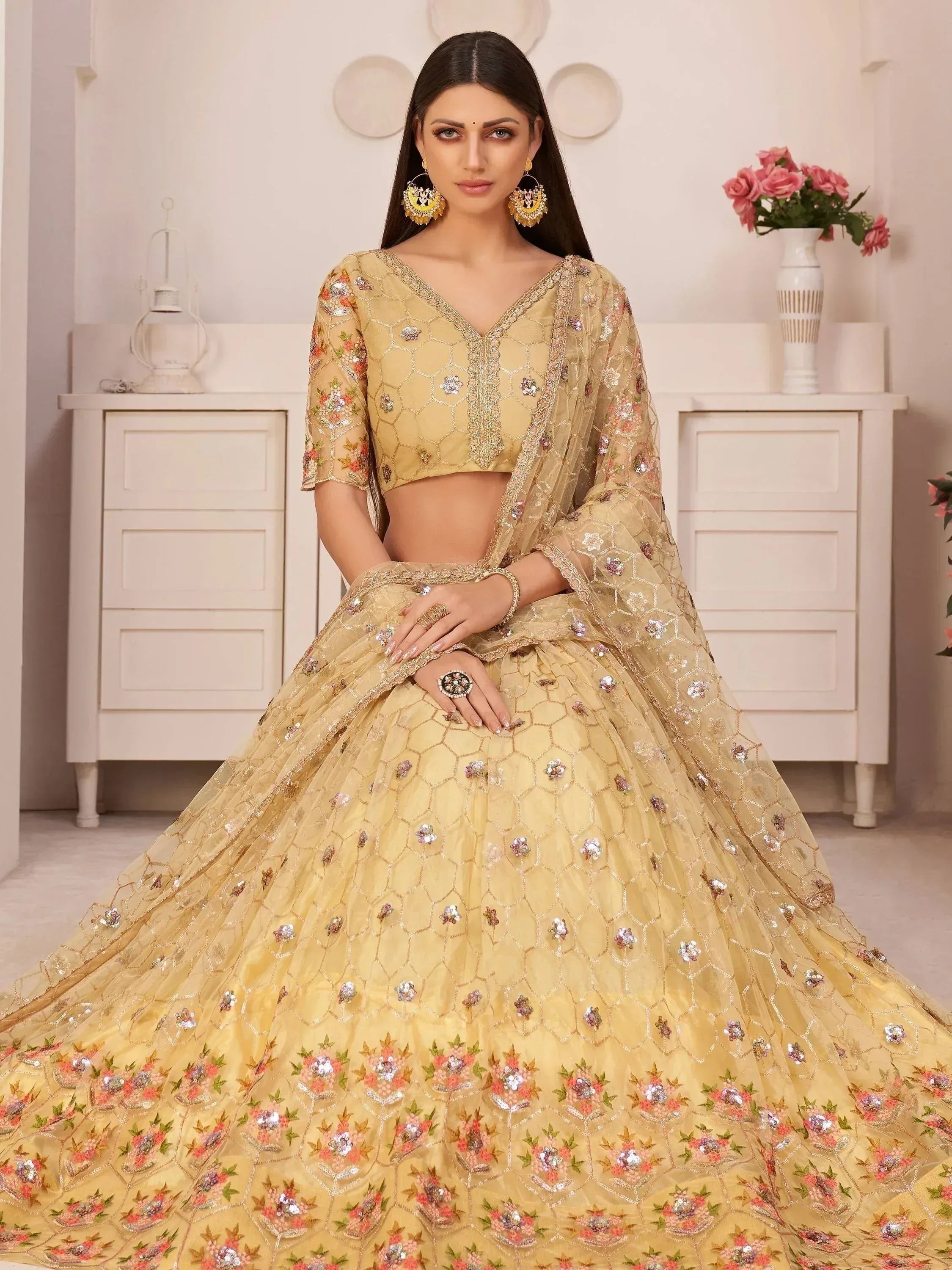 Elegant gold lehenga choli with floral embroidery and sequins, perfect for Indian weddings and festive occasions.