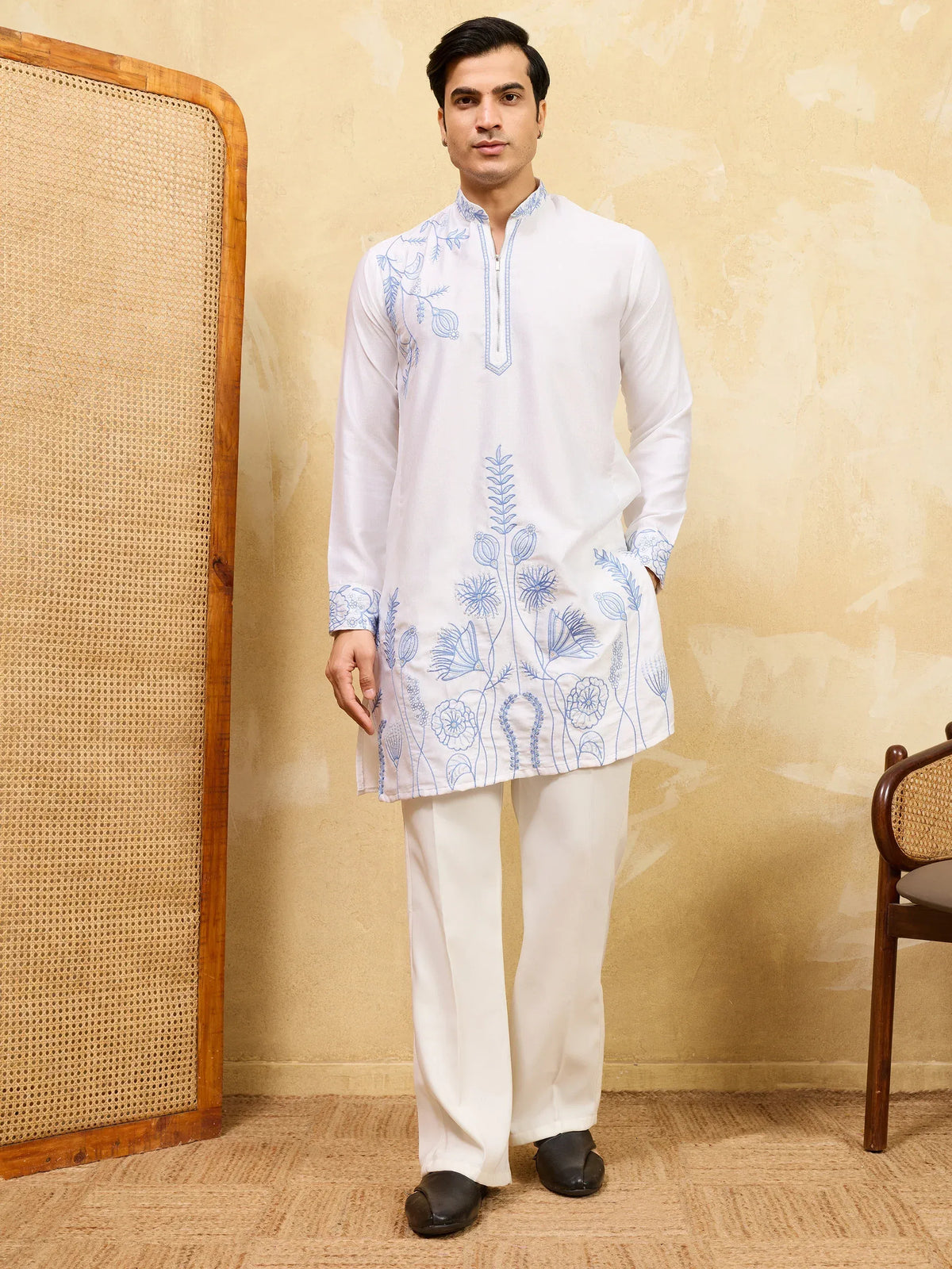 Man wearing a white embroidered kurta with matching white trousers