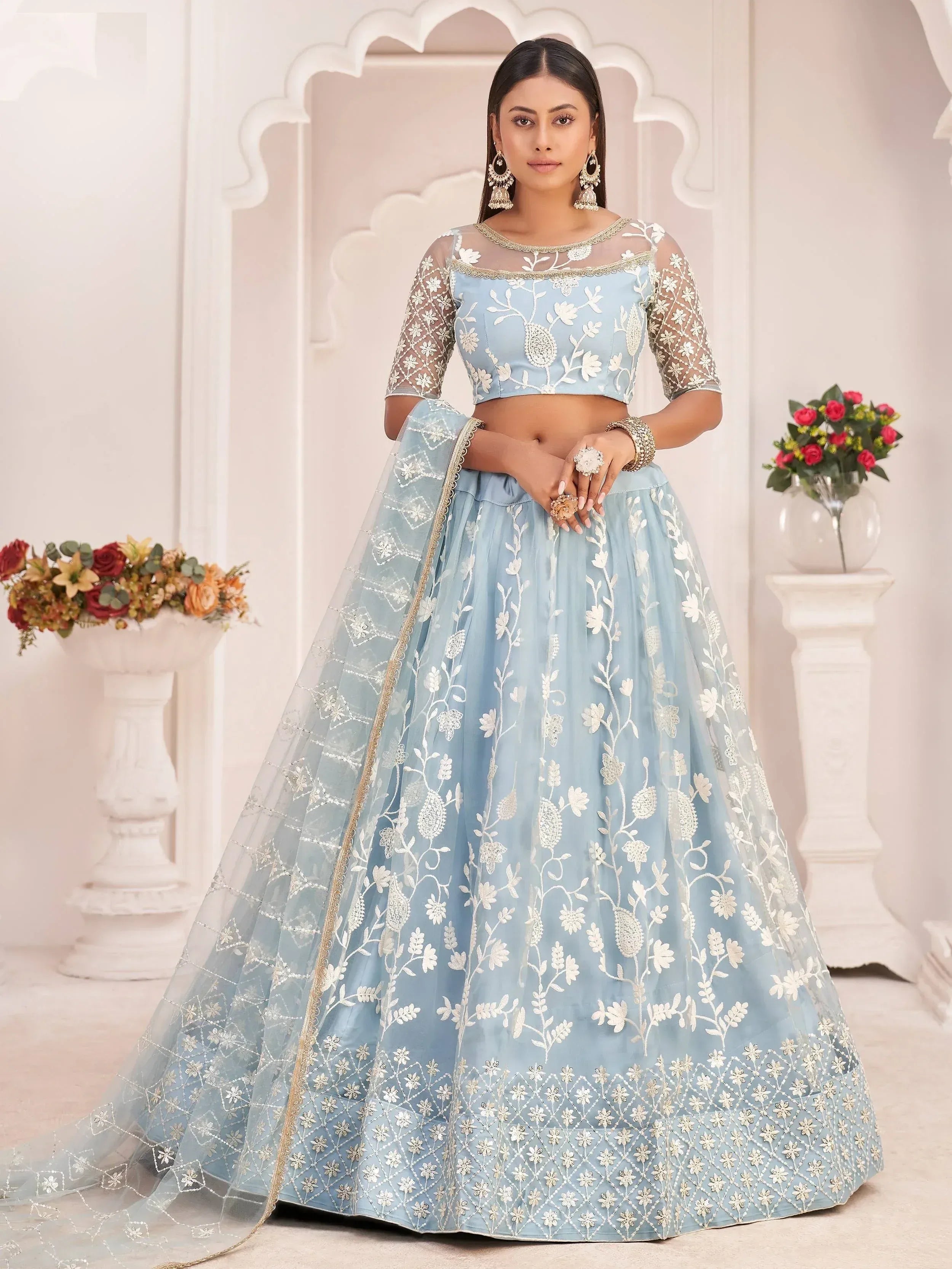 Light blue embroidered lehenga choli with floral motifs and sheer sleeves, perfect for Indian ethnic wear occasions.