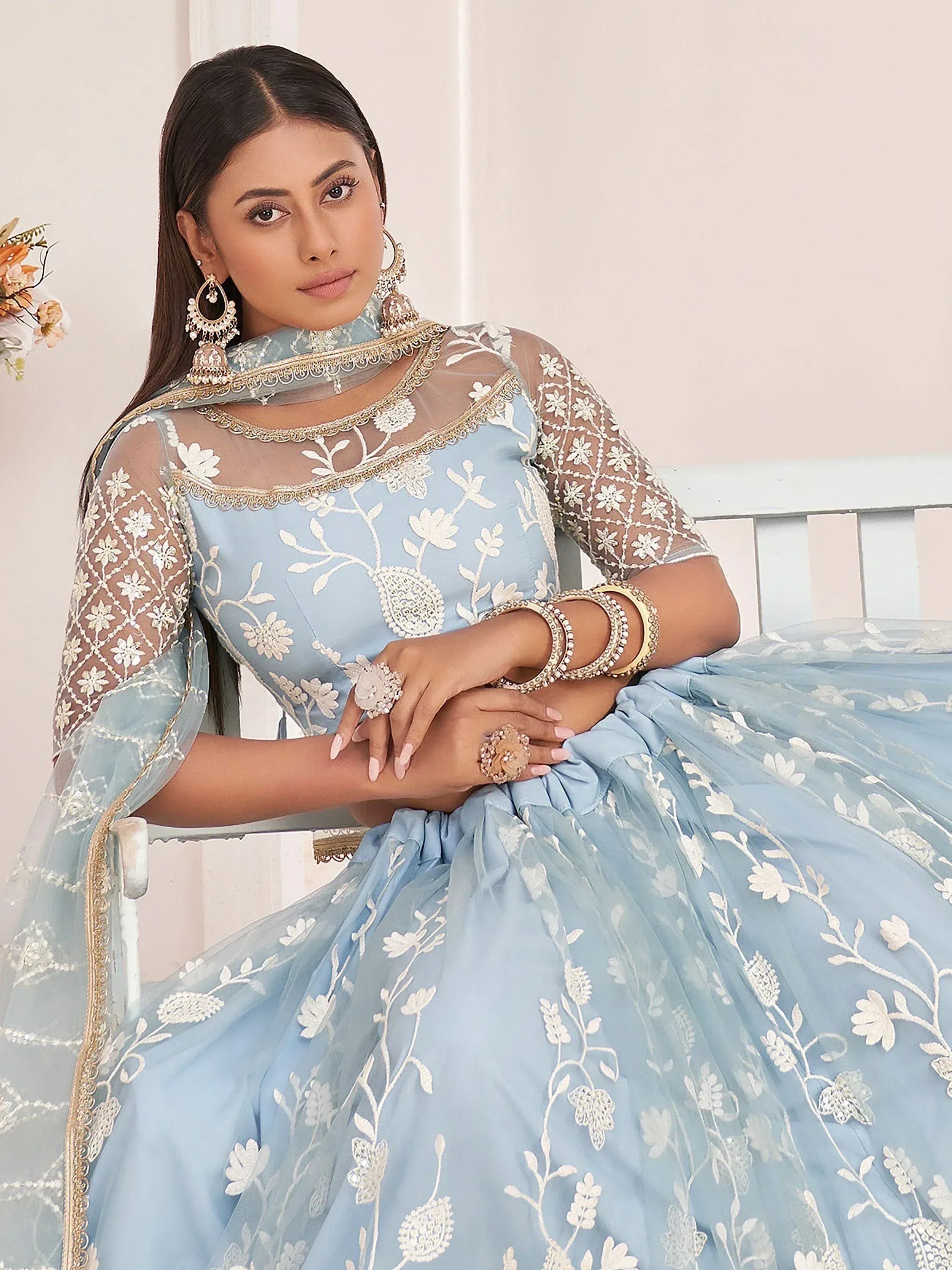 Light blue designer lehenga choli with white floral embroidery and sheer overlay, perfect for Indian ethnic wear.