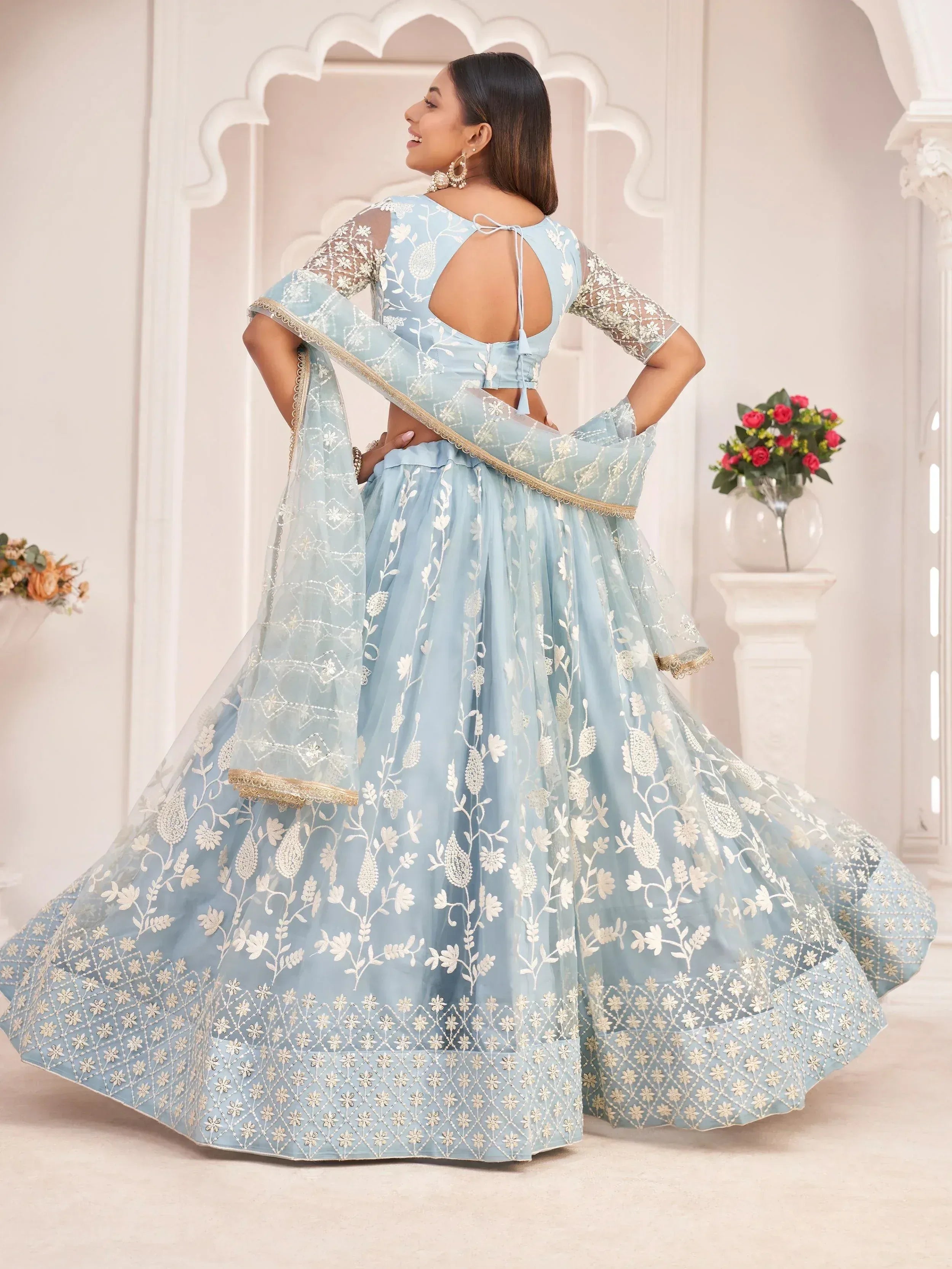 Light blue embroidered lehenga choli with floral motifs and sheer sleeves, perfect for Indian ethnic occasions