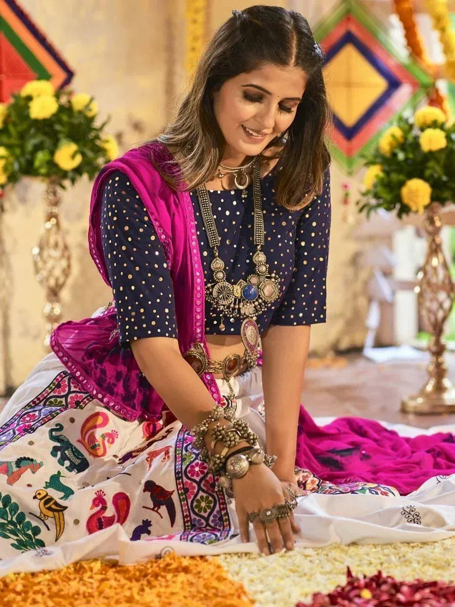 Woman in ethnic Indian lehenga choli with colorful embroidery, traditional jewelry, and festive floral decor