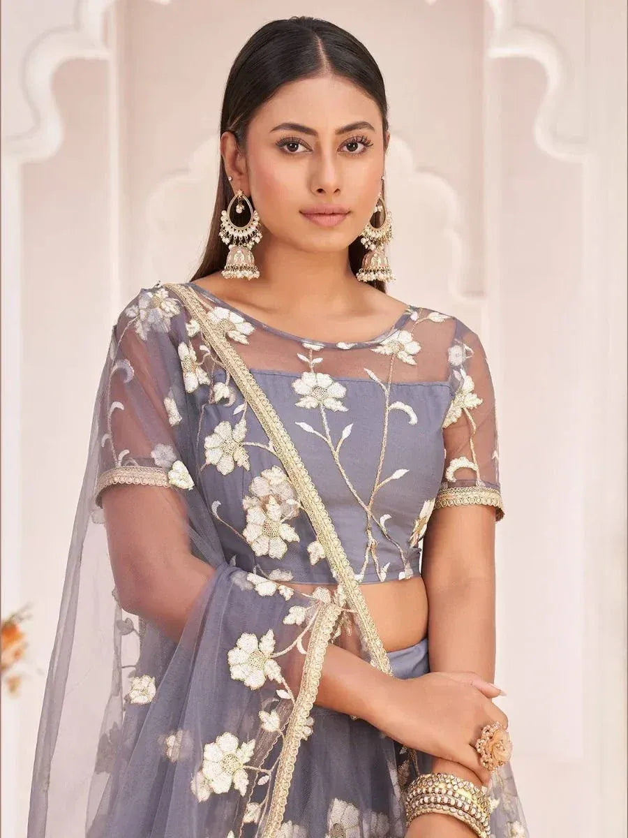 Grey floral embroidered lehenga choli with sheer overlay and gold trim, perfect for Indian ethnic occasions