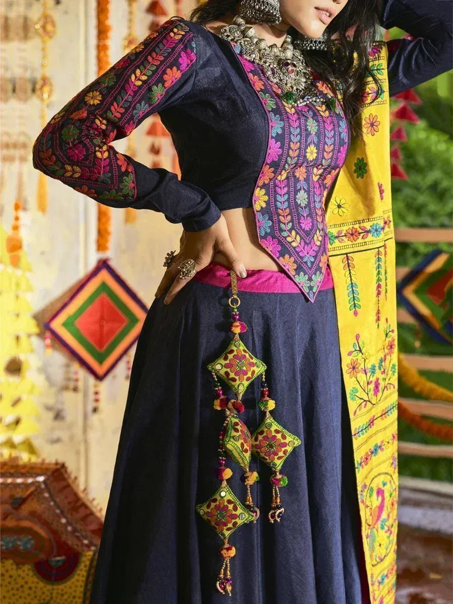Indian ethnic wear with embroidered navy blue top, pink waistband, and yellow dupatta, styled with traditional jewelry.