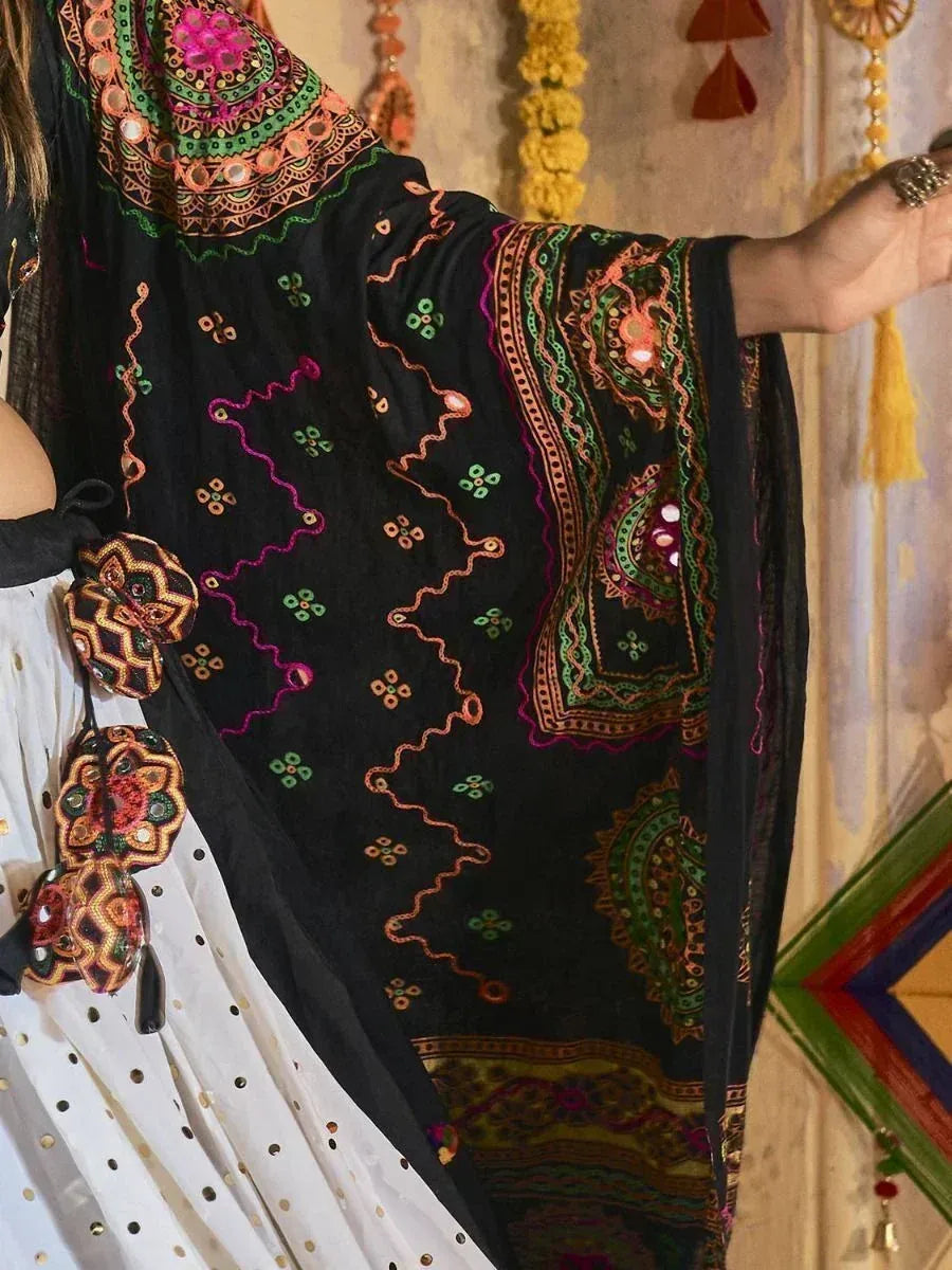 Black embroidered ethnic dupatta with colorful mirror work and floral patterns, paired with white polka dot skirt