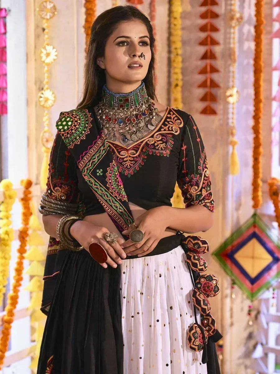 Black and white embroidered ethnic lehenga choli with colorful mirror work and traditional jewelry