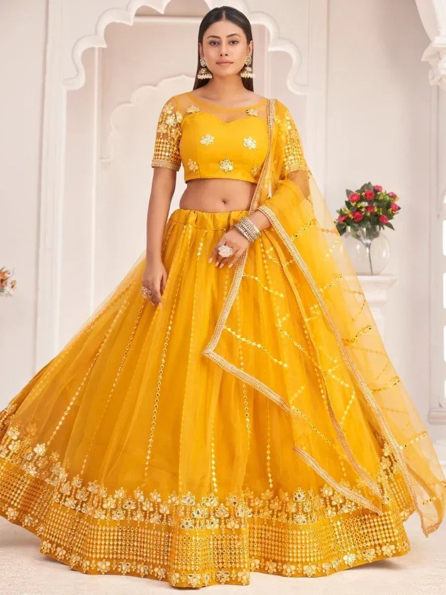 Yellow designer lehenga choli with gold embroidery and mirror work, perfect for weddings and festivals