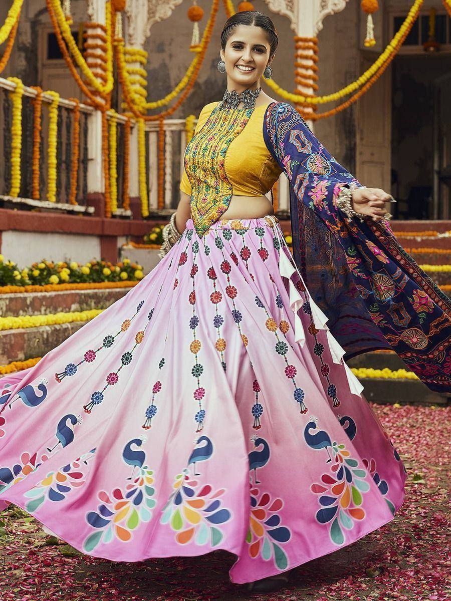 Woman in vibrant pink lehenga with peacock print, yellow blouse, and embroidered dupatta, festive Indian ethnic wear